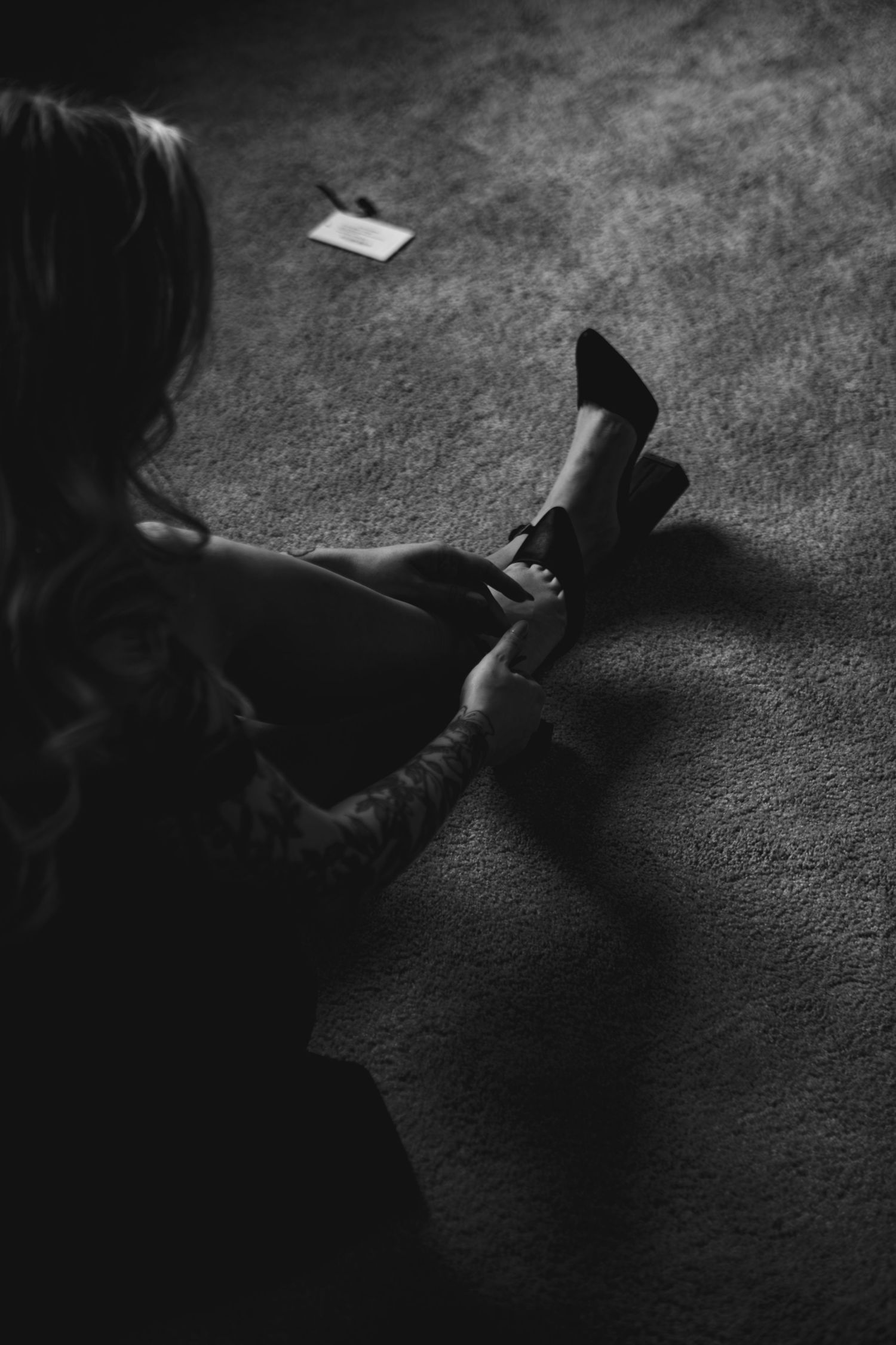 A series of silhouetted hands against a dark background reaching and touching papers in low light conditions.