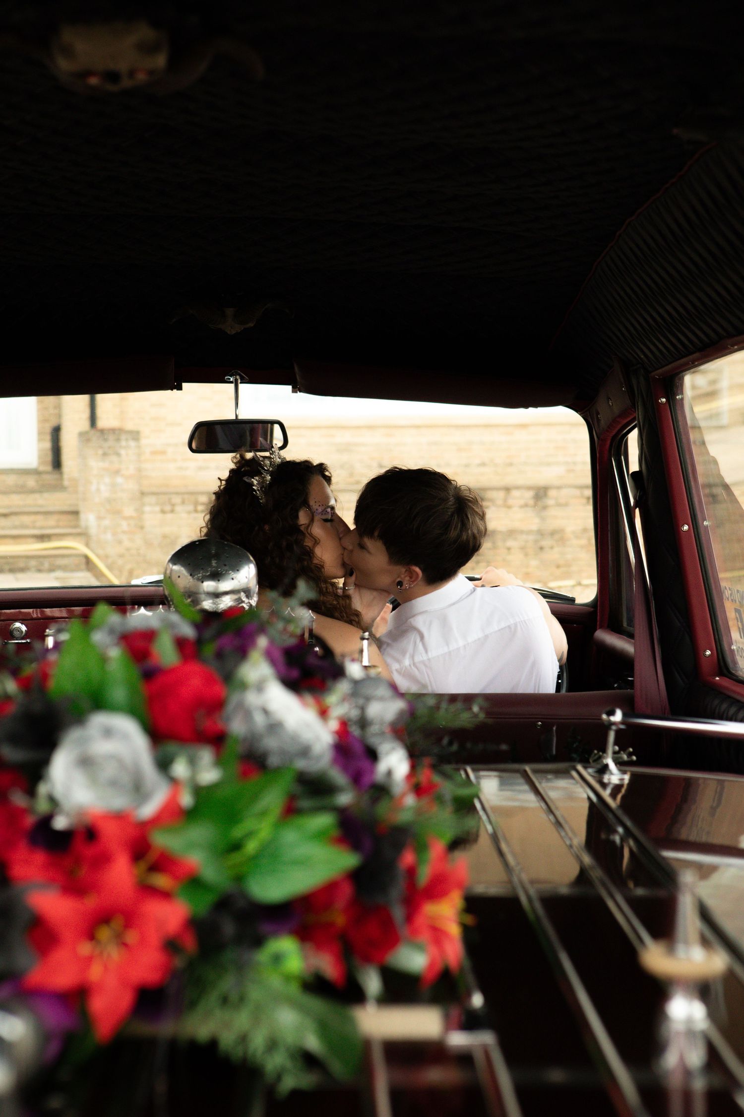 Red and purple decorative flowers adorn a car interior, suggesting a romantic or special occasion.