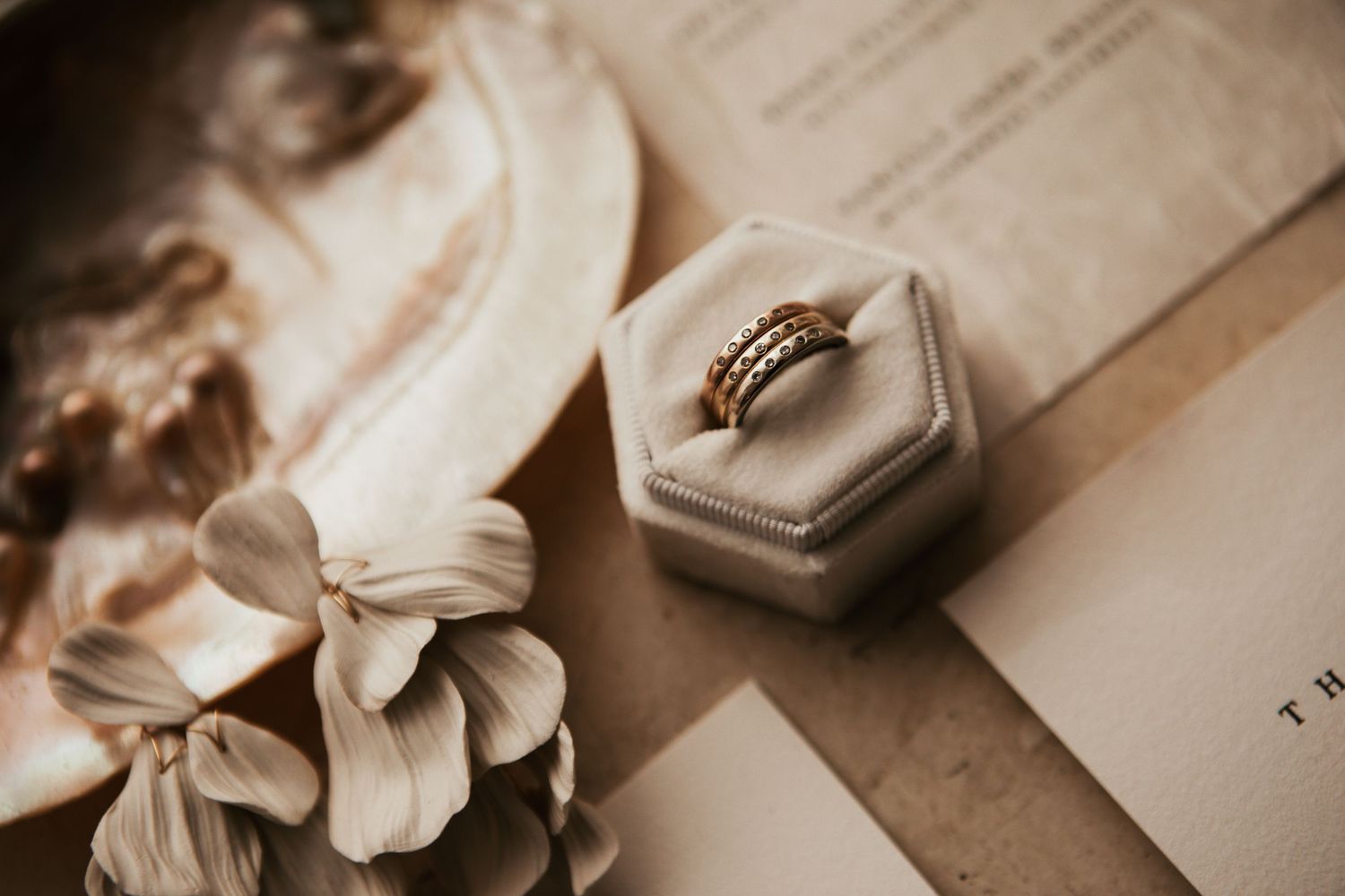 Wedding rings displayed in hexagonal ring box with delicate flowers and vintage styling.