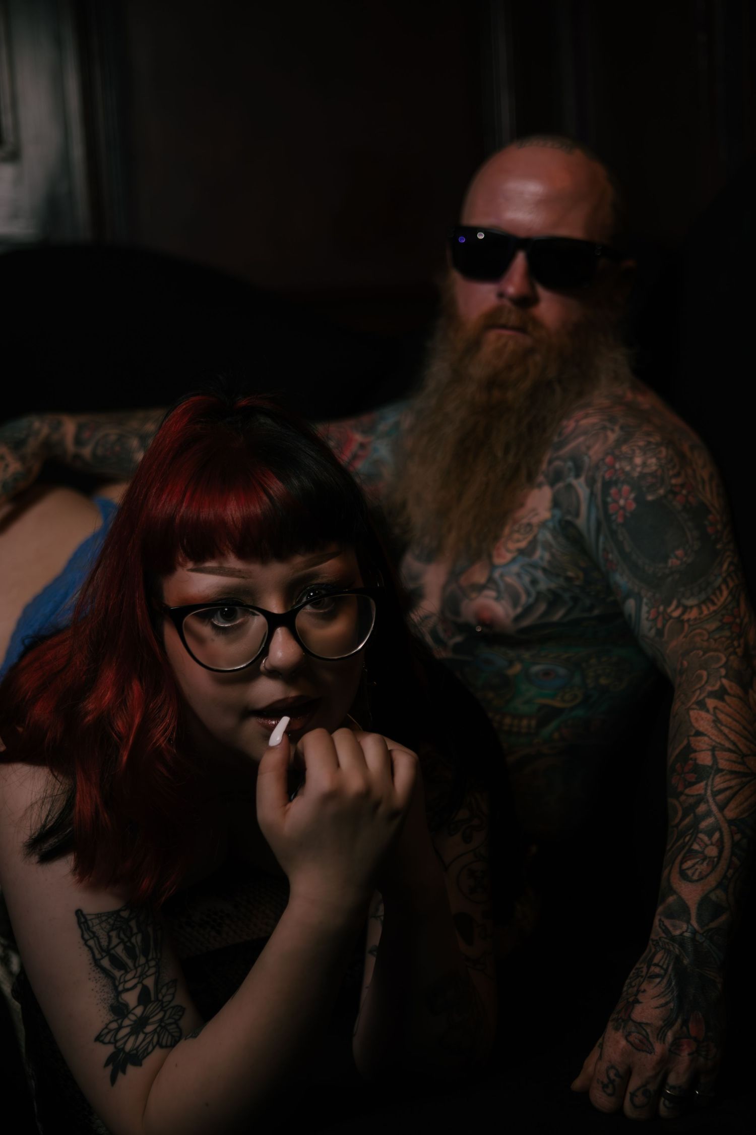 Artistic collection of moody portraits showcasing tattoo art in dark ambient lighting with stylish eyewear.