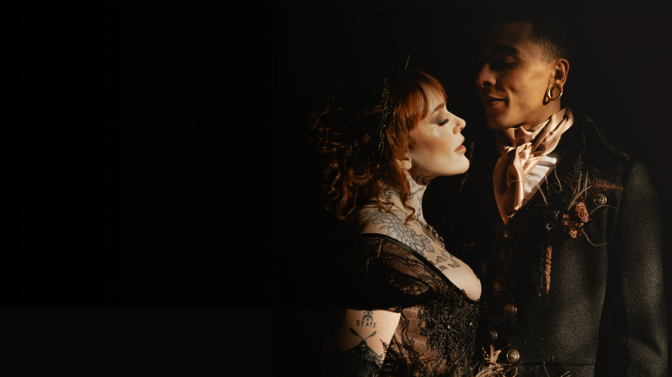 Cinematic capture of a couple in dark formal attire with moody lighting and vintage aesthetic.