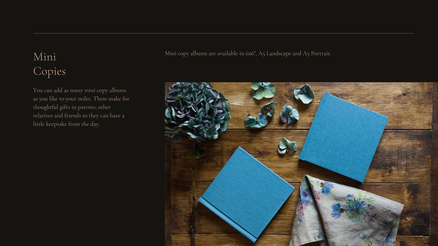 Two blue notebooks lay on a wooden surface next to chains and writing instruments in an artistic flat lay composition.