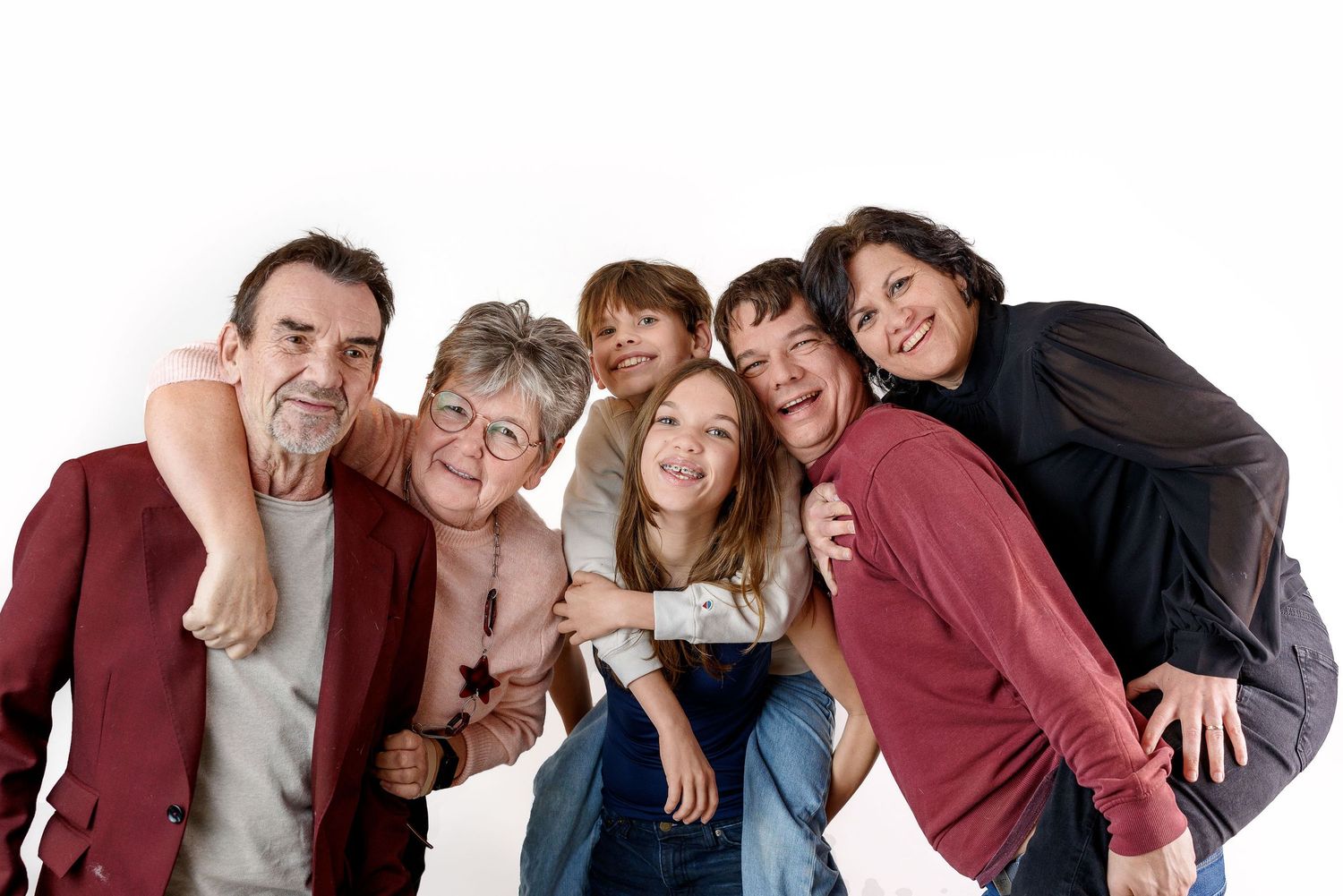 A group of diverse college students leaning in together and smiling in a friendly pose.