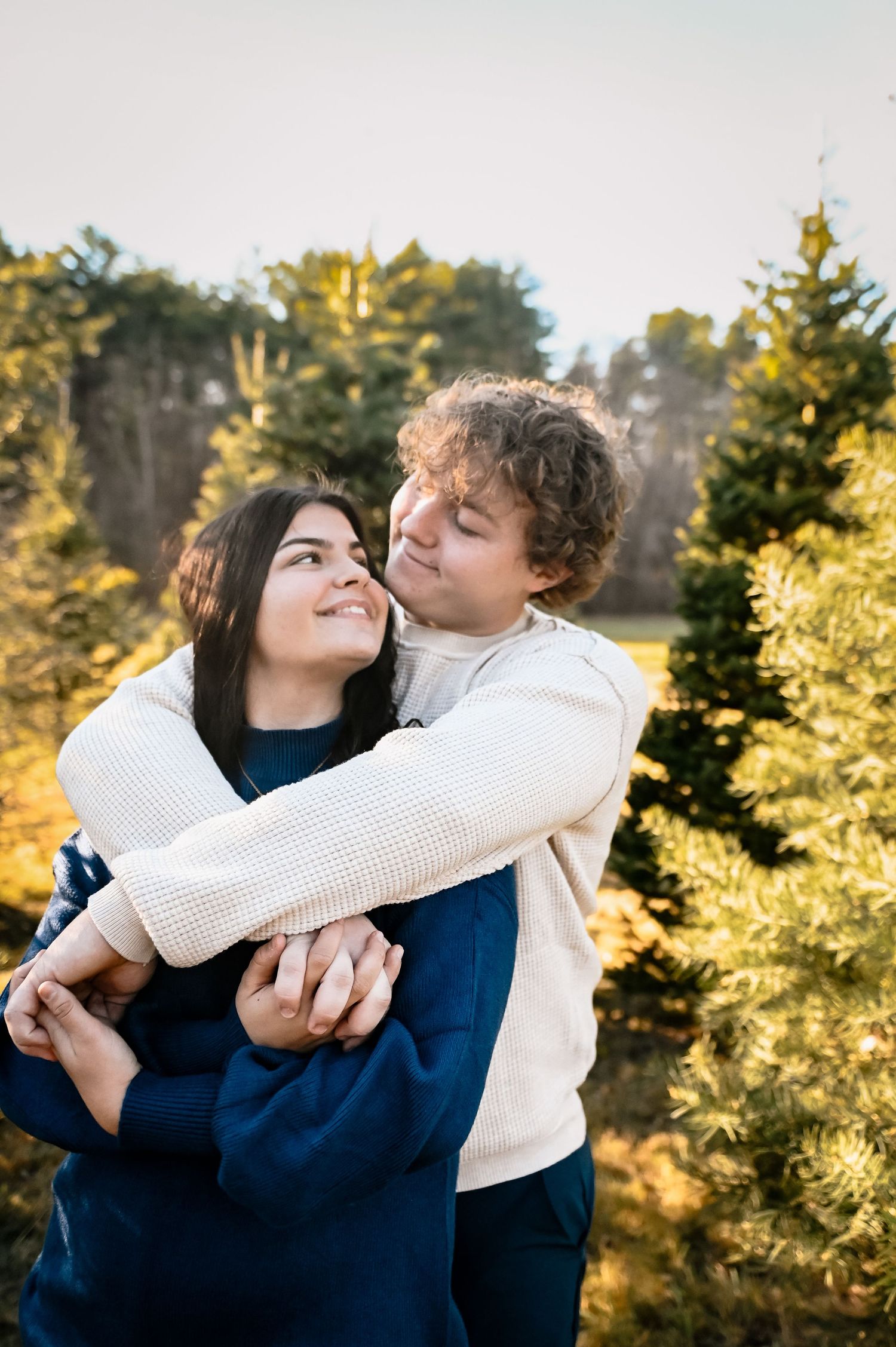 Engagement photography session in Boston Ma featuring two people embracing during golden hour in a romantic outdoor setting.