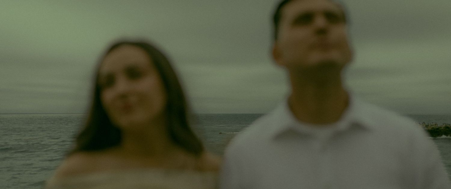 Intentionally blurry photo of couple with the ocean behind them.