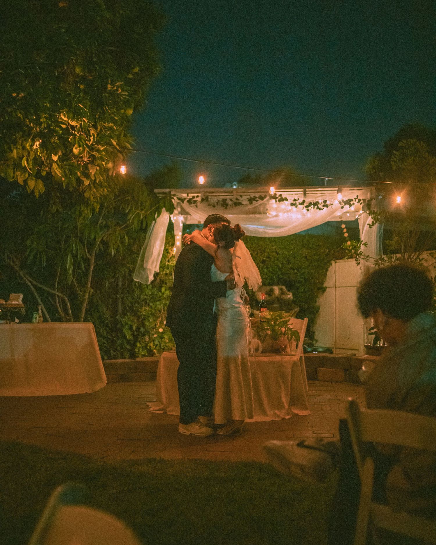 Bride and groom having their first dance as a married couple in their backyard wedding.