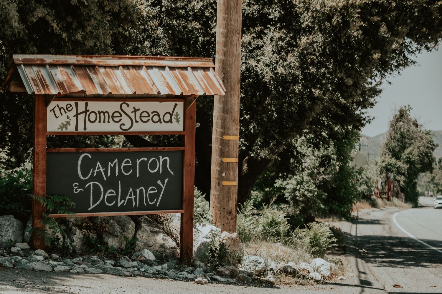 Rustic wooden sign at The Homestead in Oak Glen displaying 'Cameron & Delaney' the bride and groom