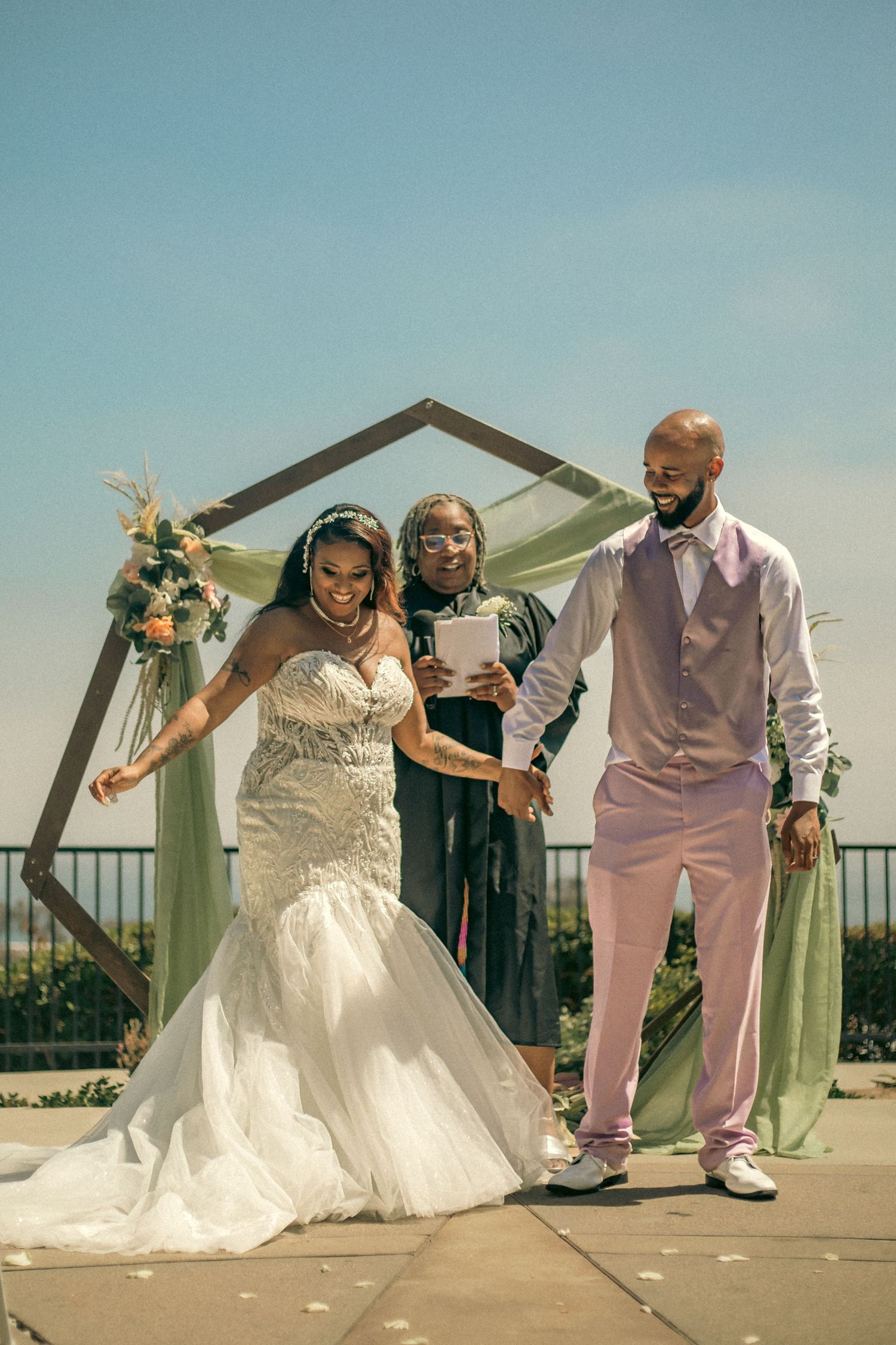 Bride and groom dancing down the aisle after saying