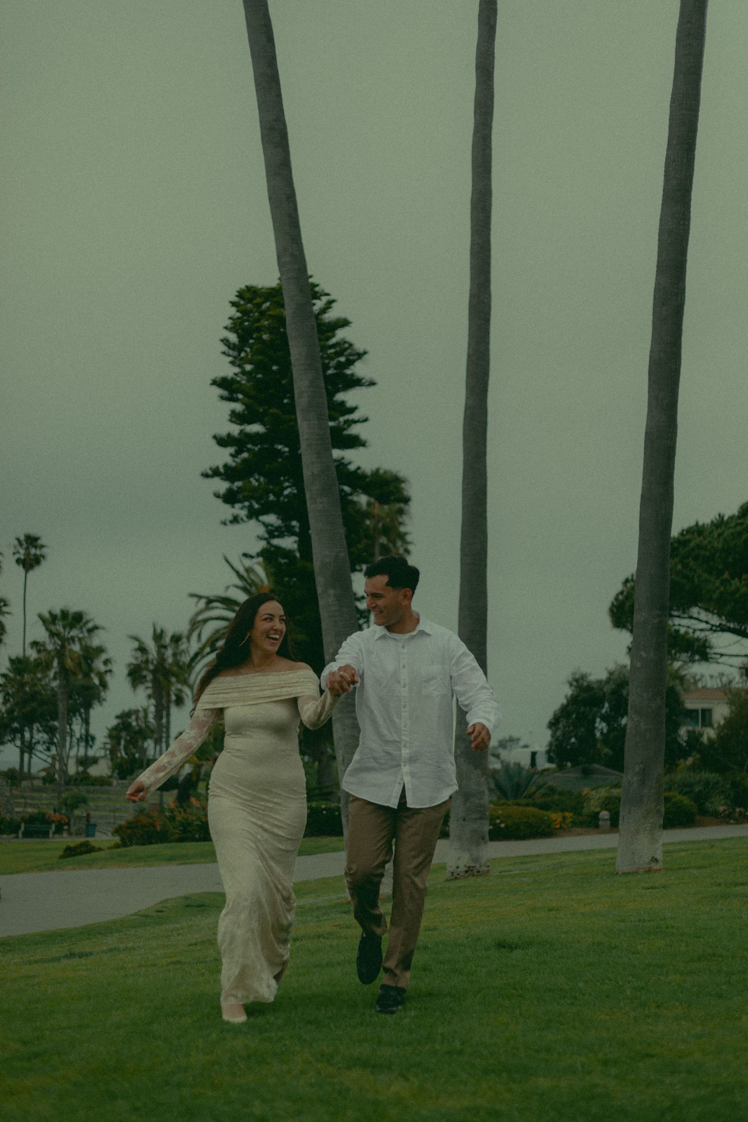 Elopement couple happily running at Heisler Park in Laguna Beach.