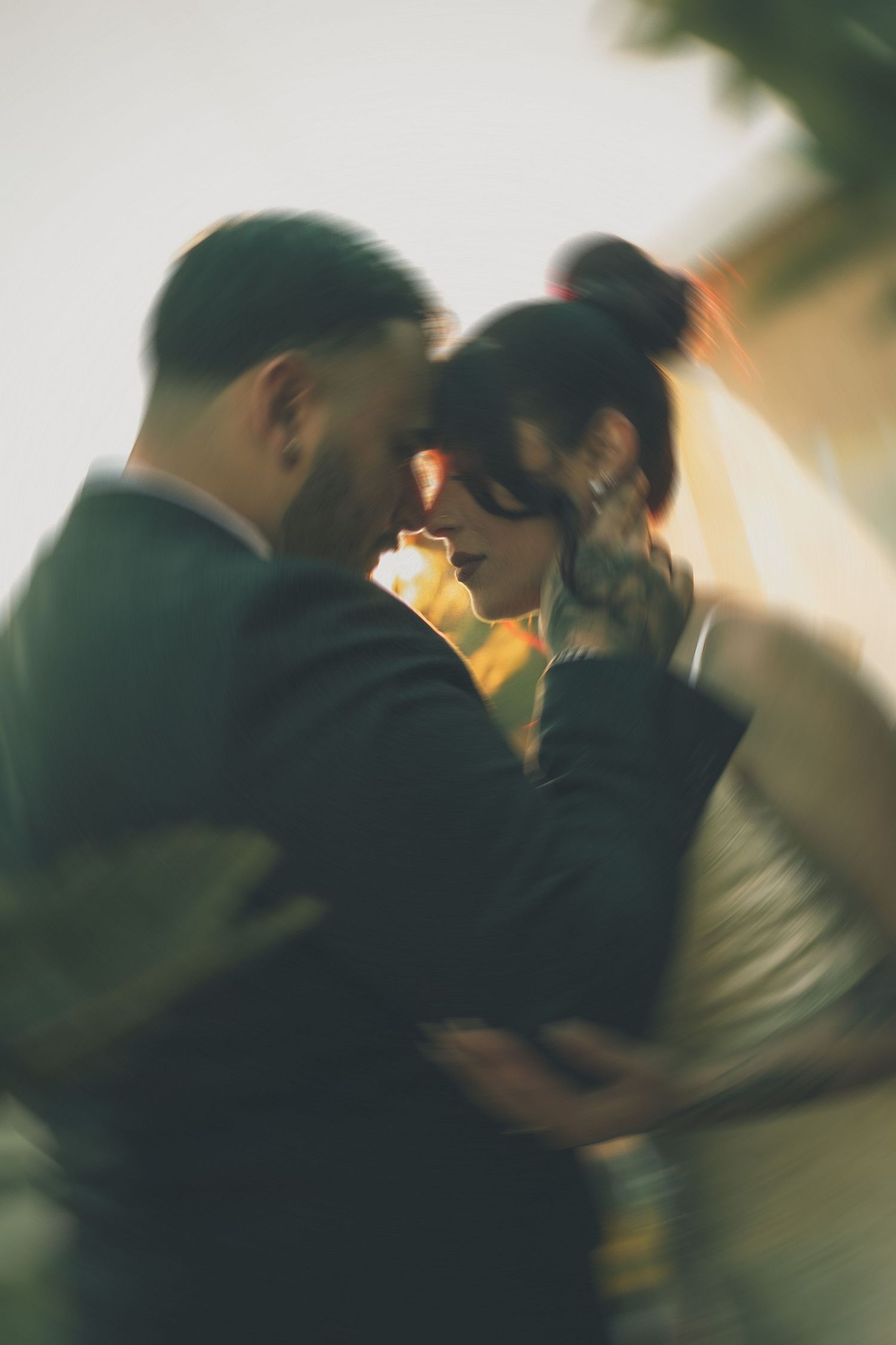 A romantic couple shares an intimate moment in soft lighting during a dance, creating a dreamy atmosphere.