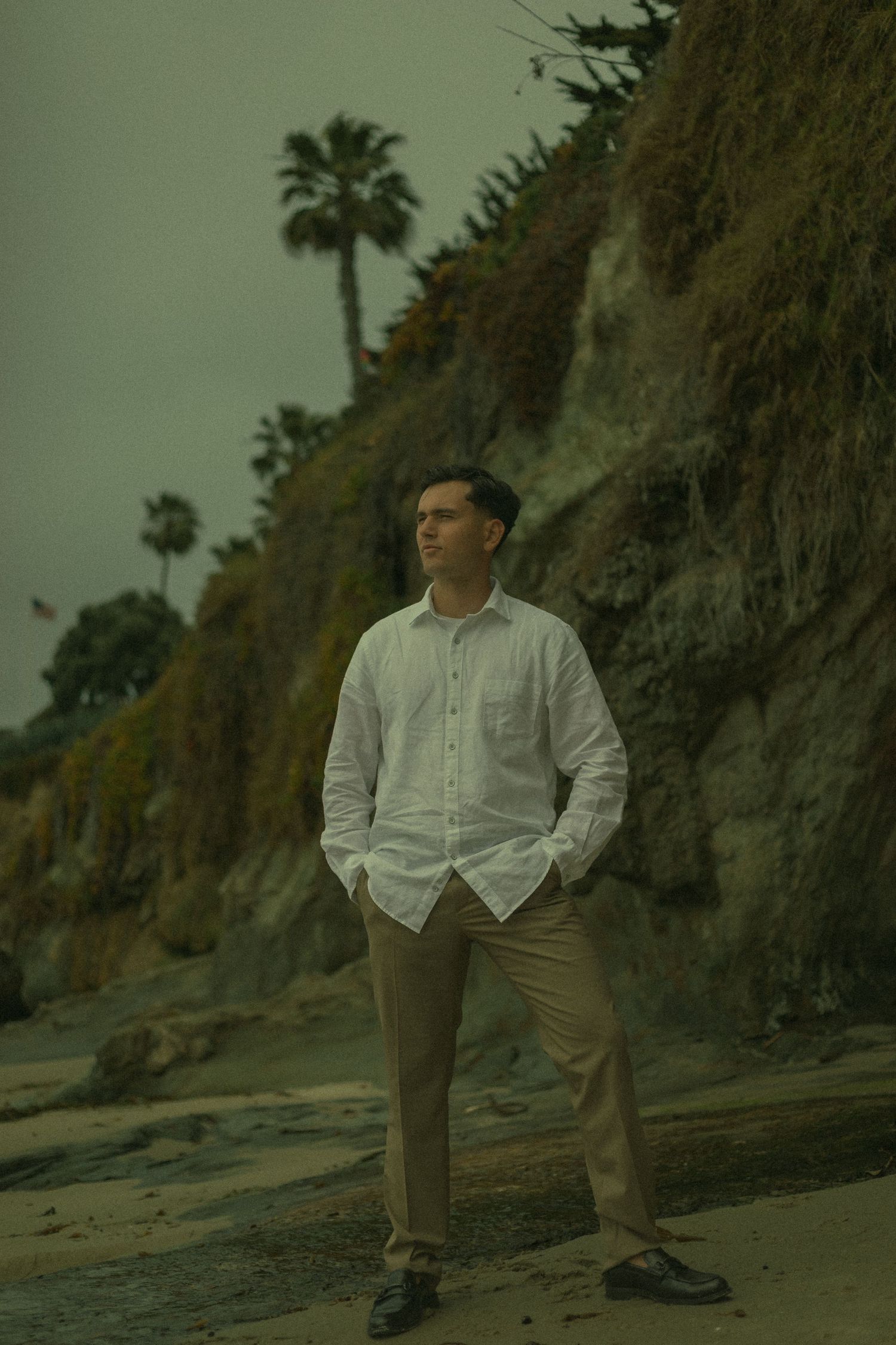 Man romantically standing on the beach looking out towards the horizon in Southern California.