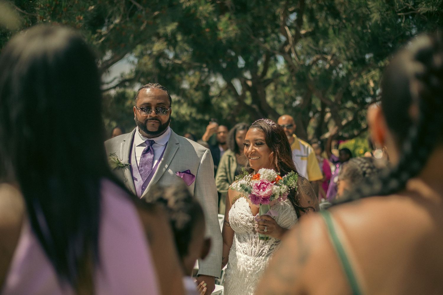 Father walks daughter down the aisle at an outdoor wedding ceremony to be wed