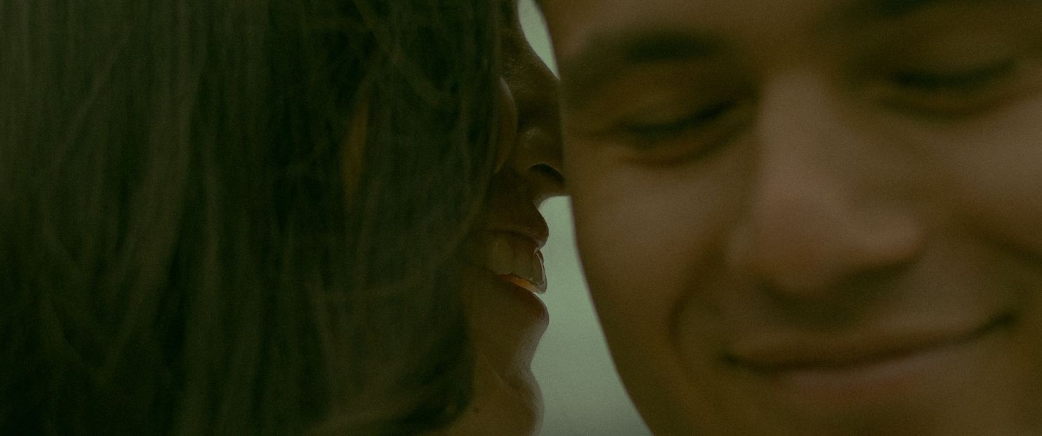 Wife whispering loving secrets into her husband's ear while they have a fun day at the beach.