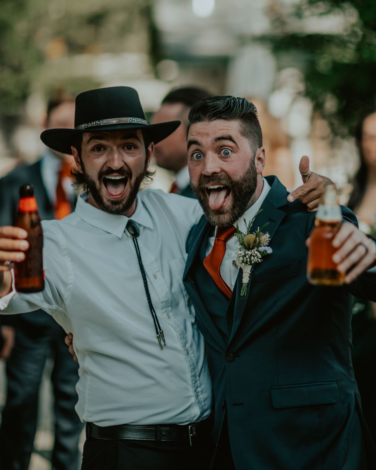 Groom and best friend sharing drinks and laughing together before the wedding ceremony