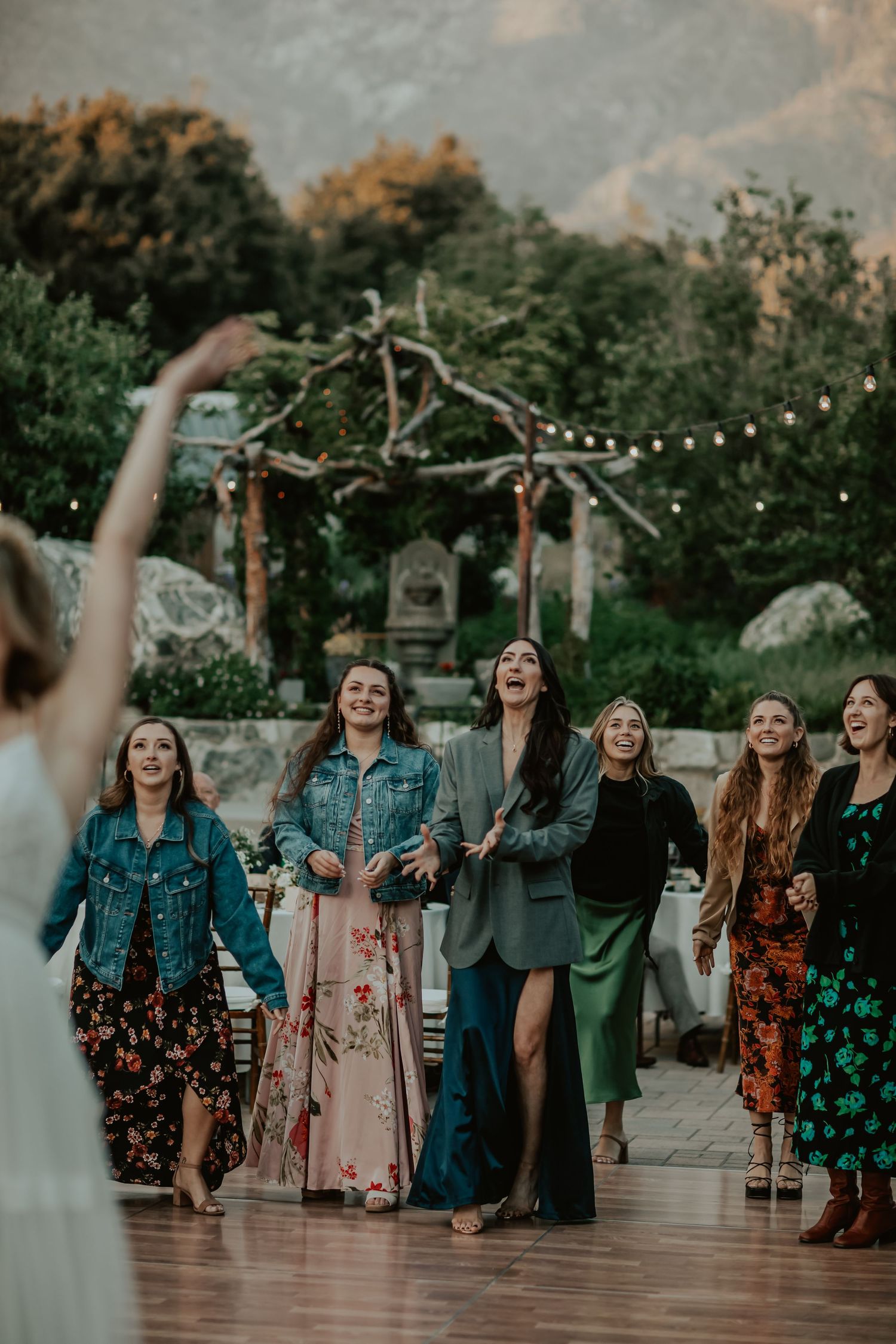 Single ladies ready to catch the bouquet as the bride throws it into the air