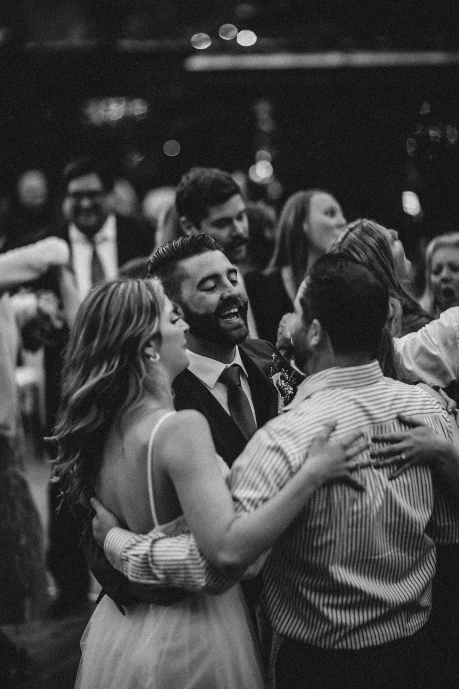 Bride and groom joyfully celebrating their union with another guest on the dance floor