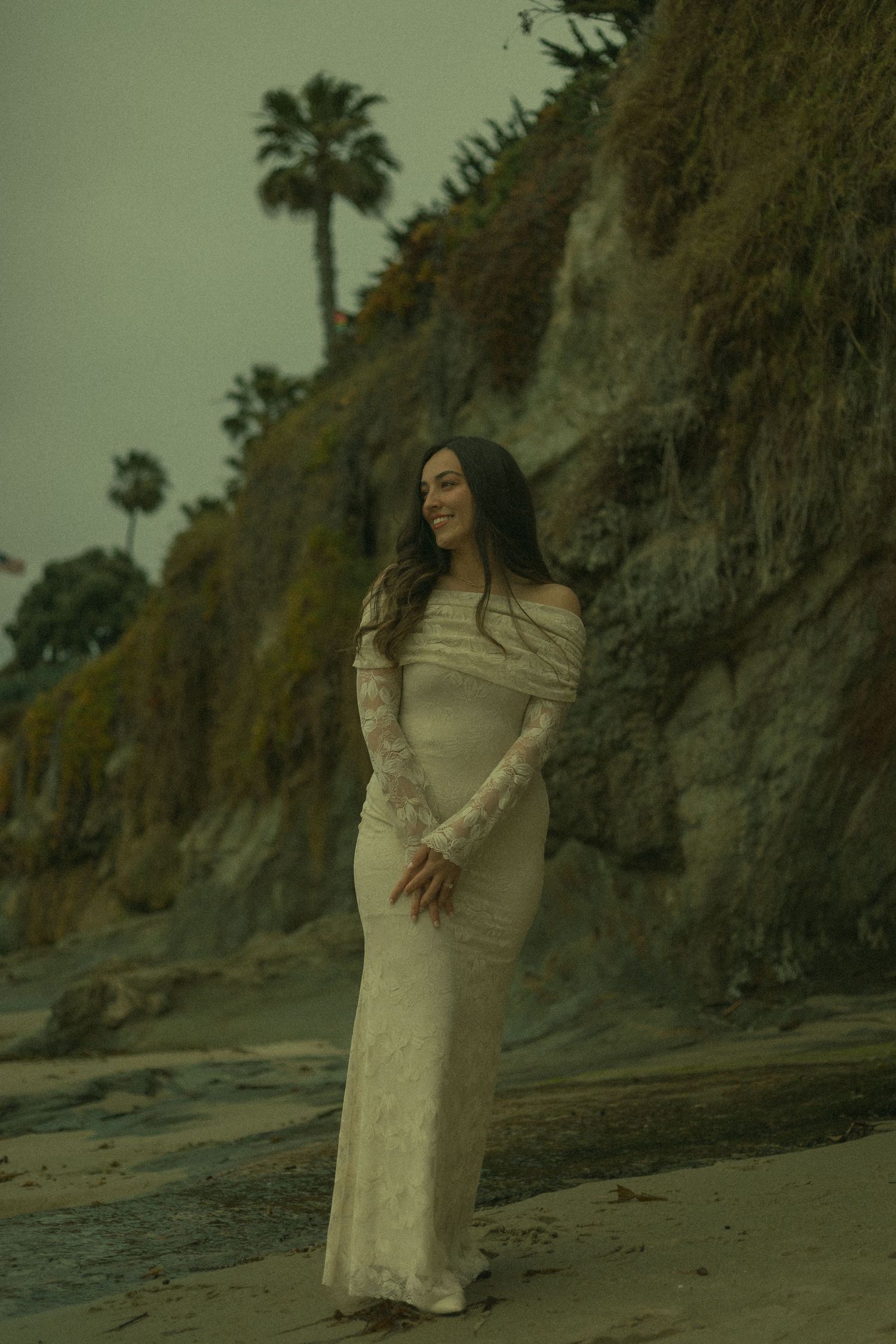 Woman in beautiful lace wedding dress standing on the beach in Laguna.
