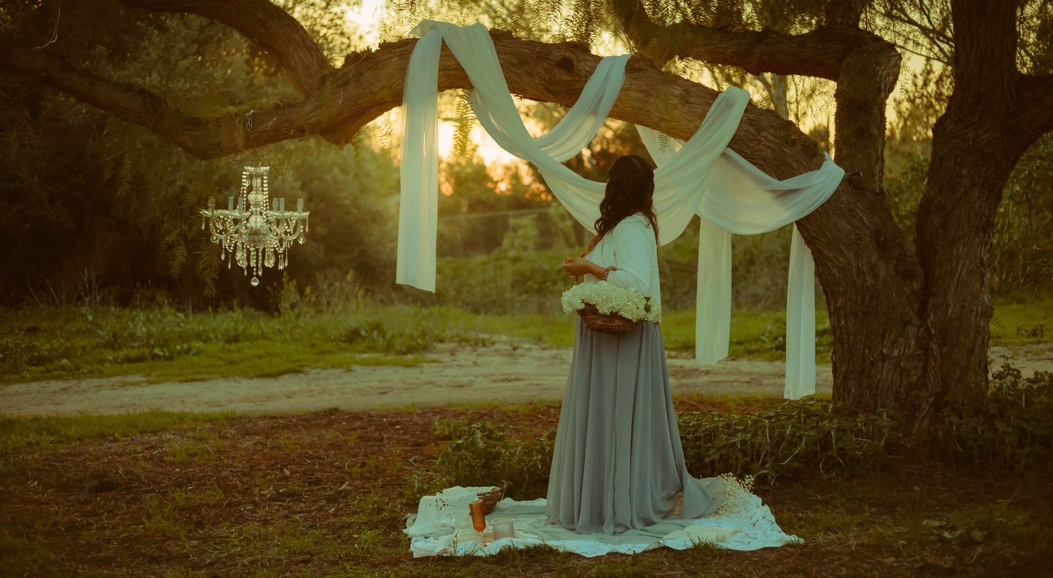 Southern California mommy and me mini sessions with elegant draped fabric, a glistening chandelier, and florals.