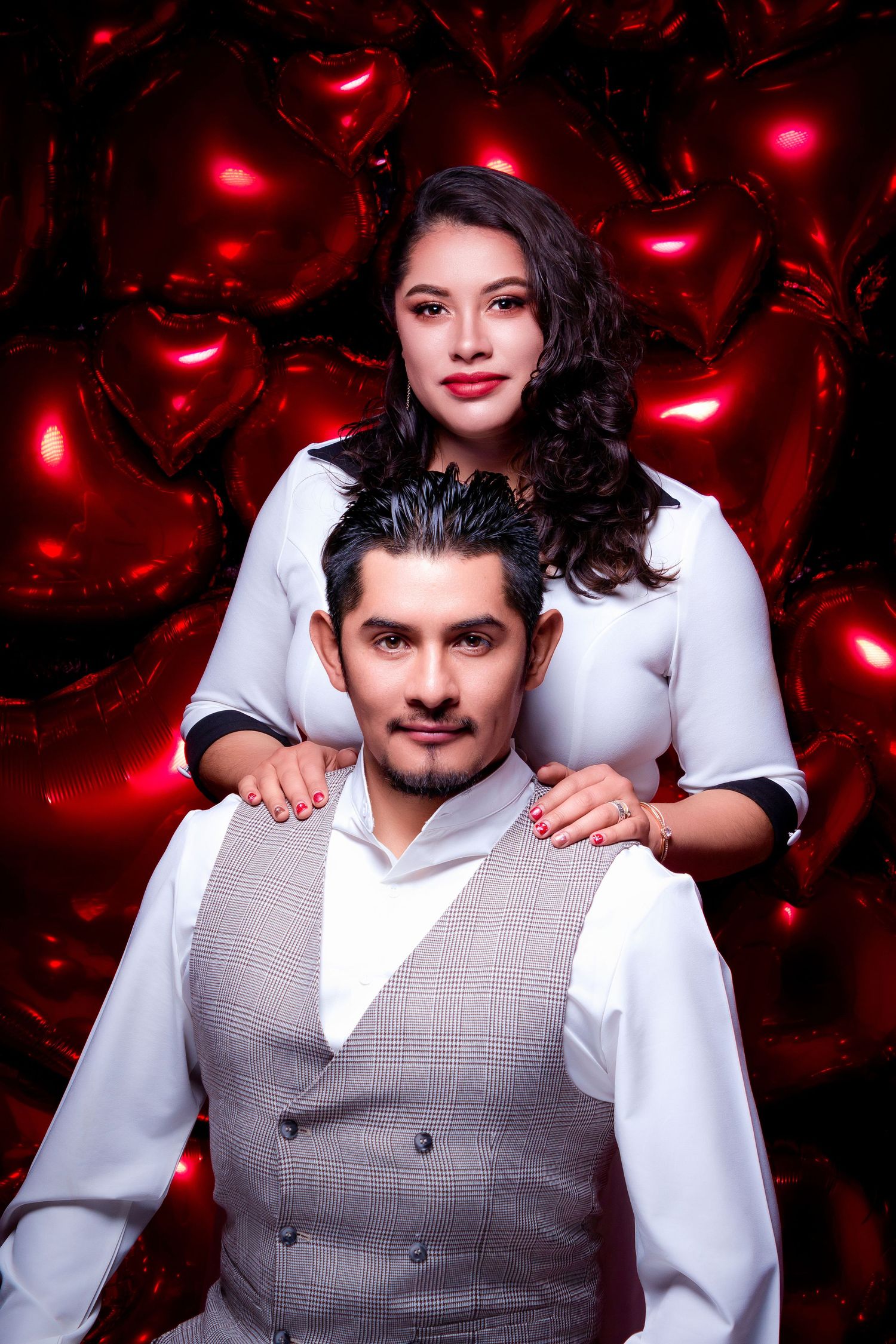 Romantic portrait against red heart-shaped lights backdrop.