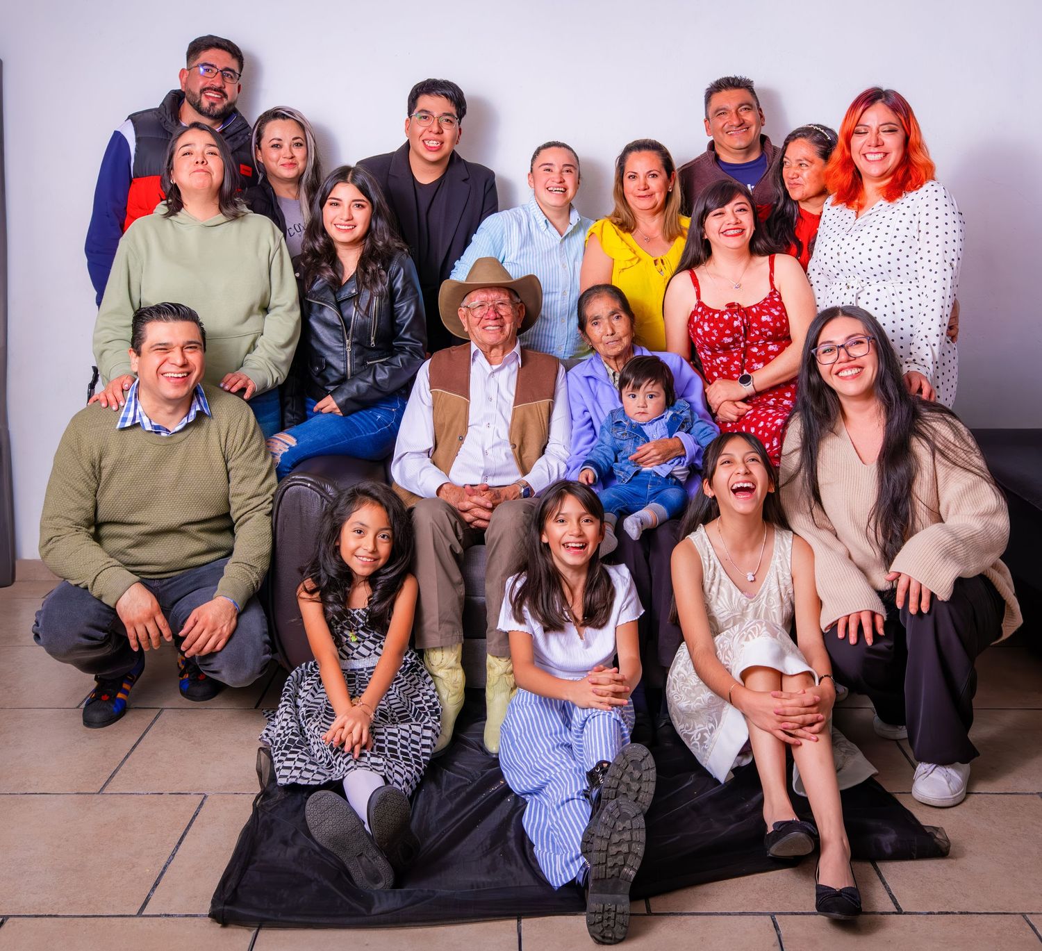 Large family group portrait with multiple generations posing together in casual attire.