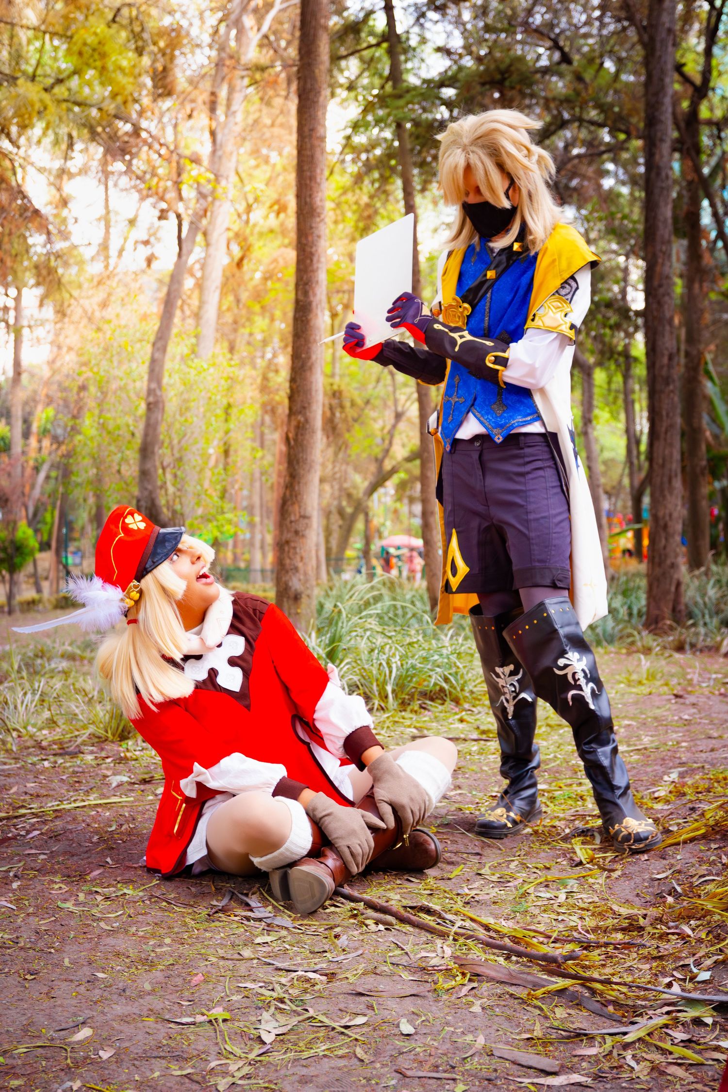 Two cosplayers in anime-inspired costumes pose dramatically in a sunlit autumn forest setting.