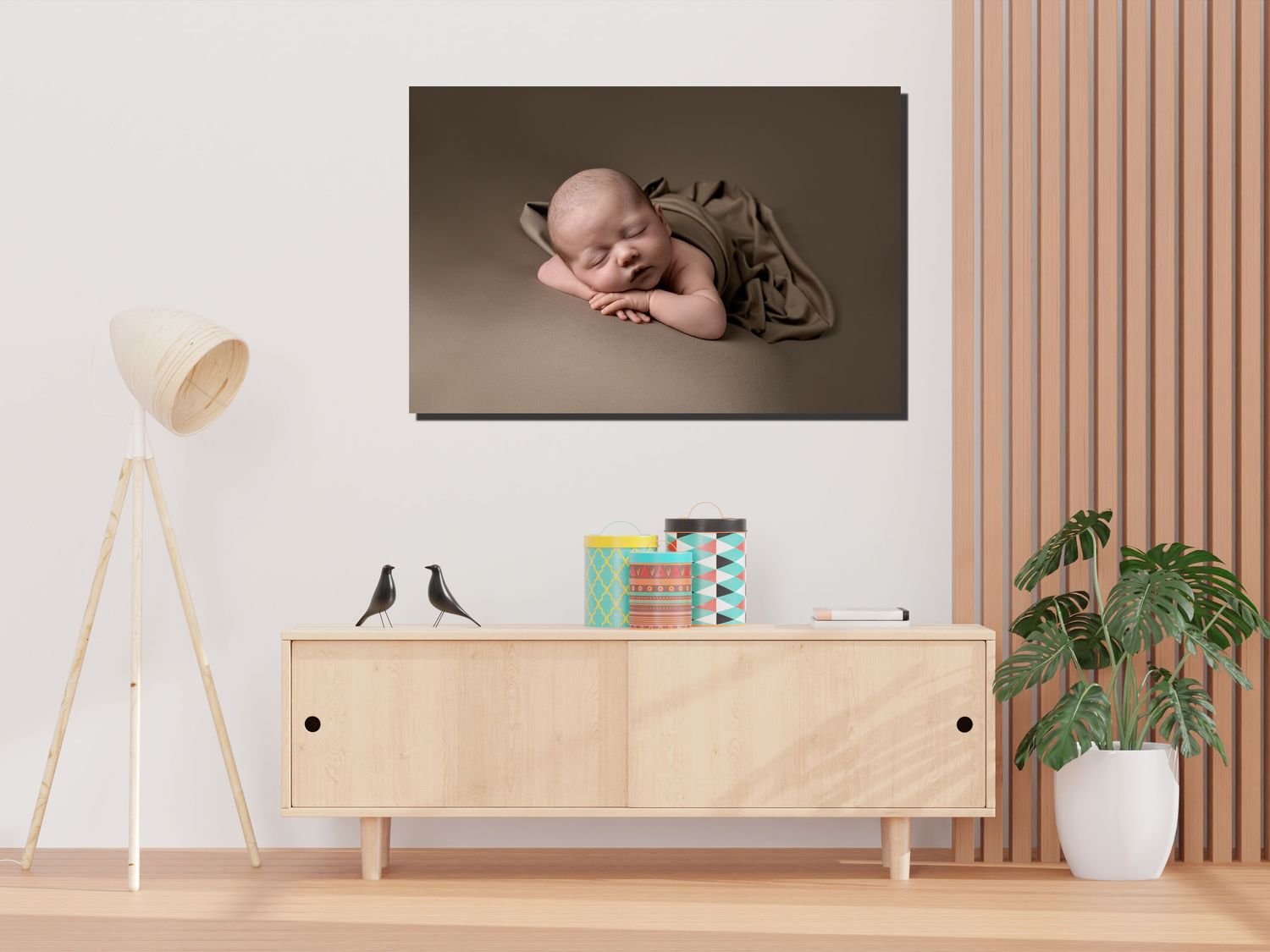 A nursery room interior featuring a large portrait above a wooden credenza with decorative accessories and plants.