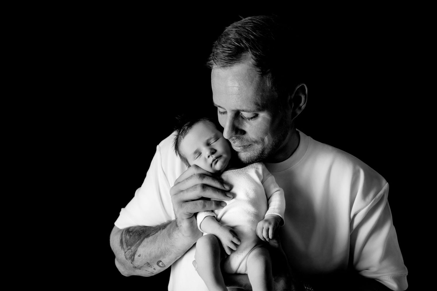 Emotional black and white portrait of parental bonding with newborn.