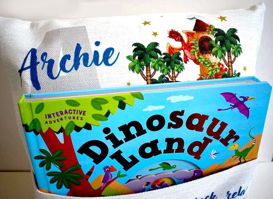 Decorative throw pillow featuring dinosaur land design with palm trees and colorful artwork.