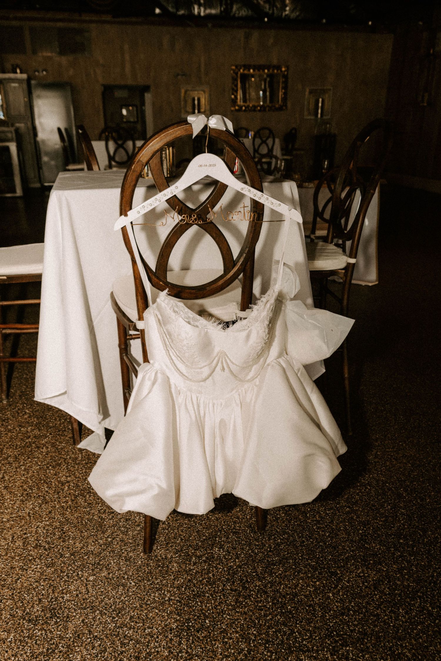 Sepia toned image series showing vintage style white christening gowns hanging on wooden hangers against dark background.