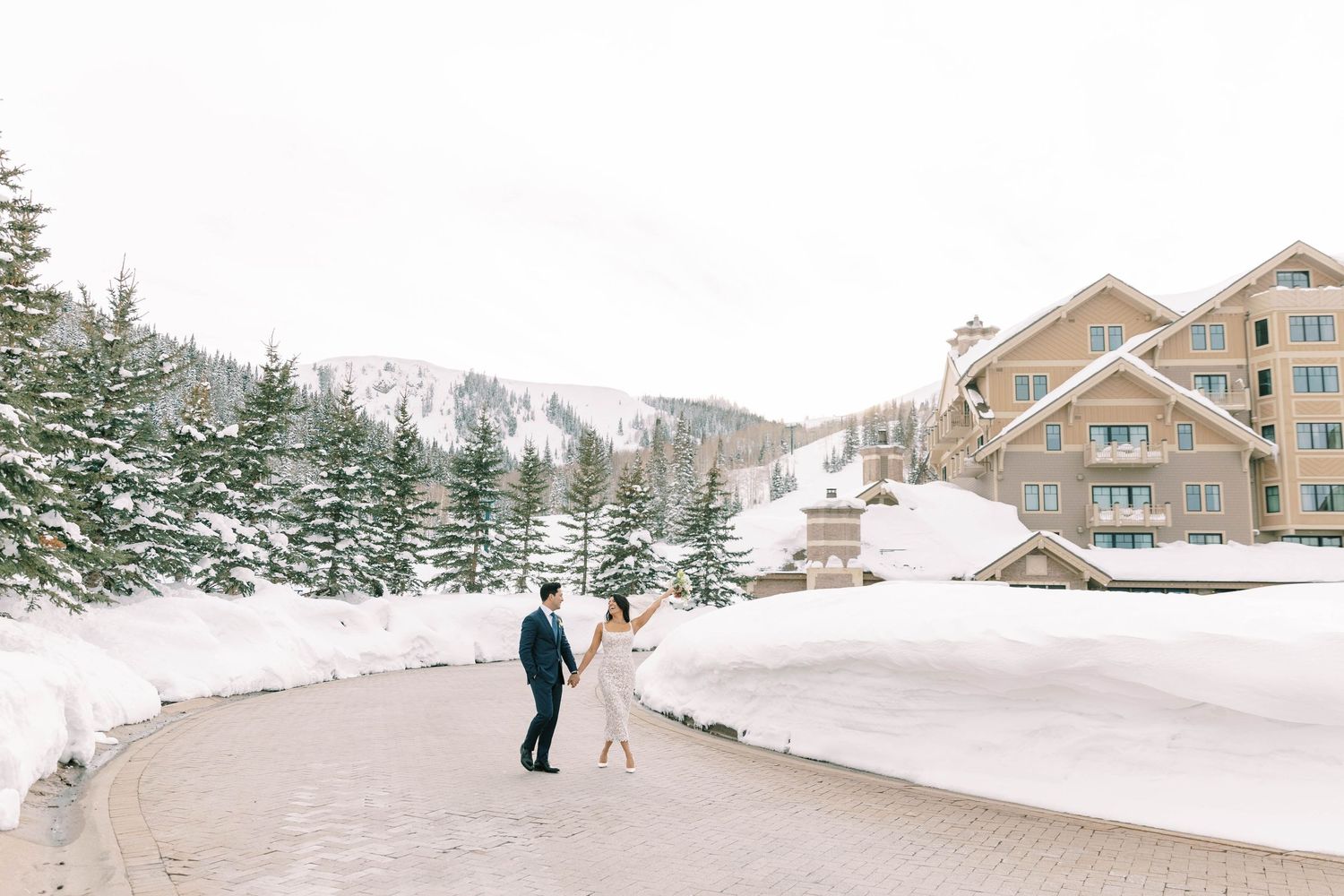 Wedding couple walking along snowy mountain path near montage deer valley.