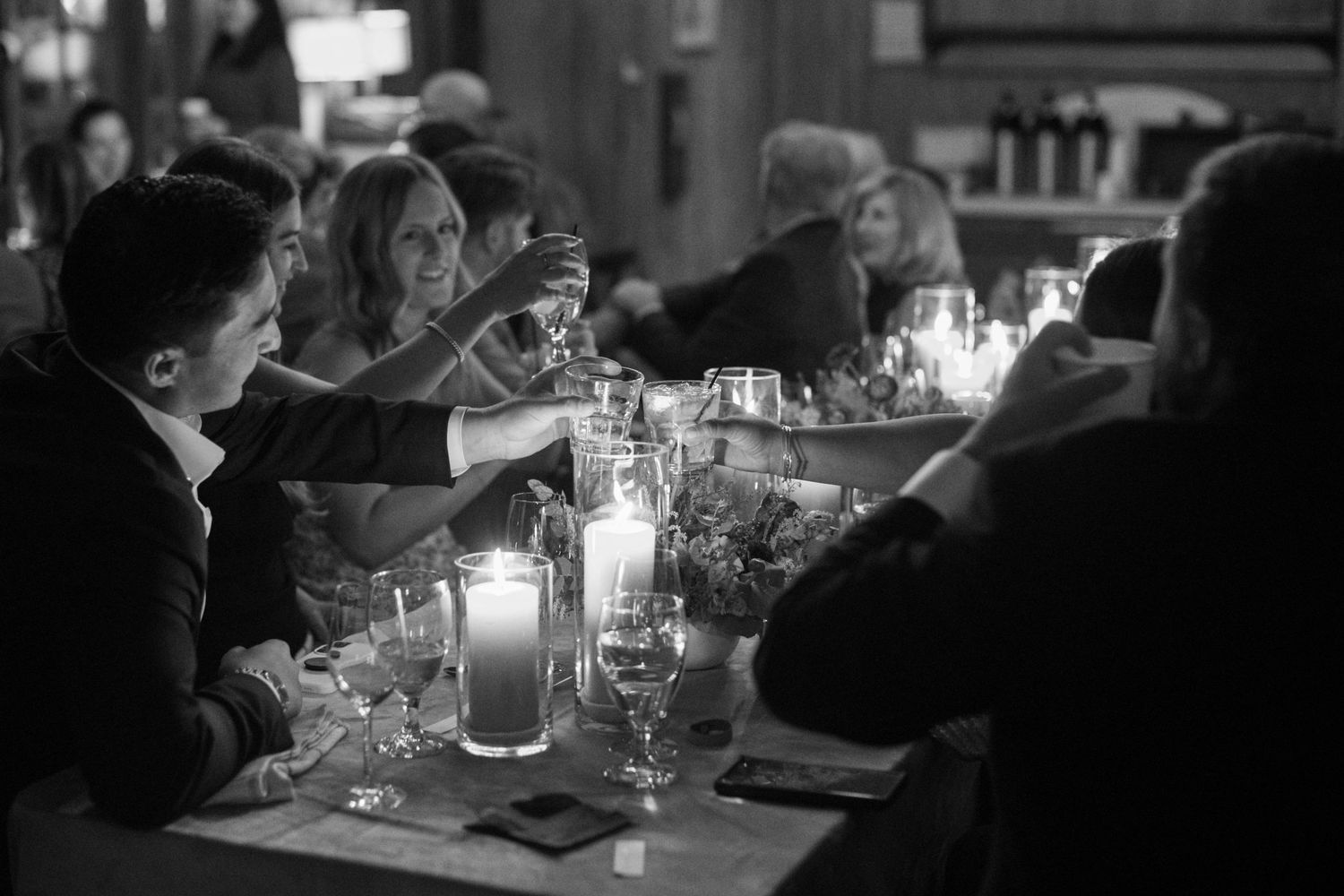 People dining and toasting at a dimly lit restaurant table with glowing candles at promontory park city.
