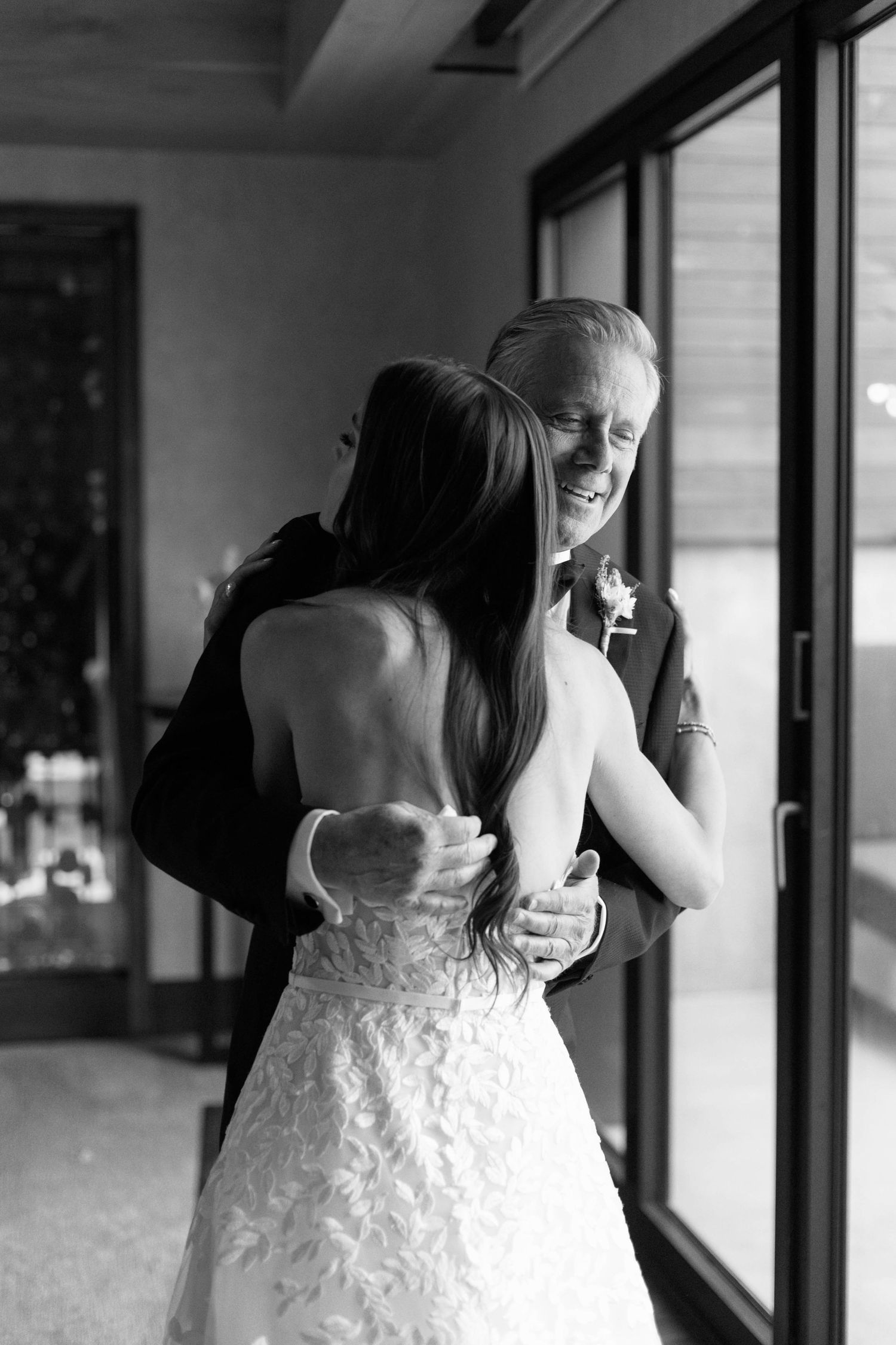 A tender embrace captured in black and white during an emotional wedding moment.