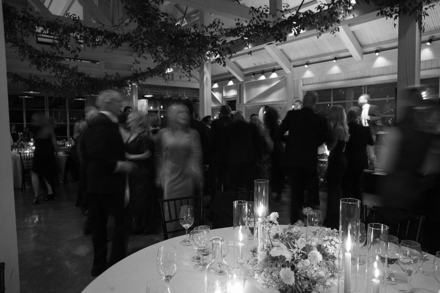 Elegant wedding reception setup with candlelit tables and guests mingling in formal attire.