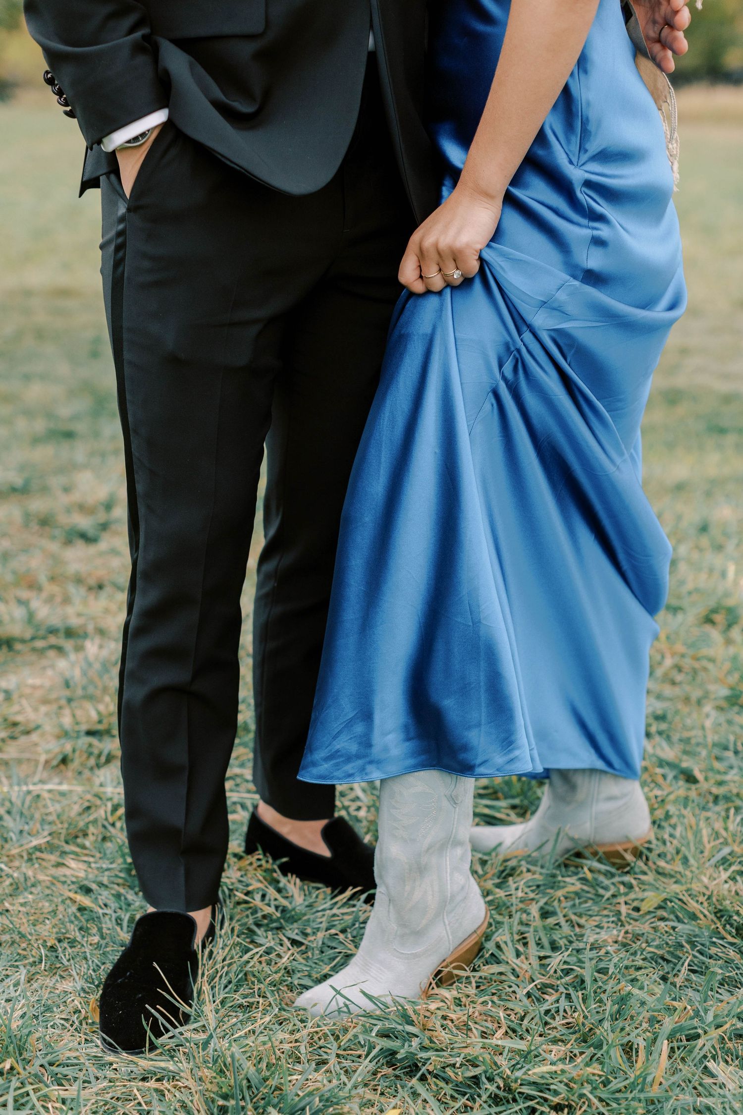 Detail shot of formal couple's attire showing blue dress and black tuxedo.