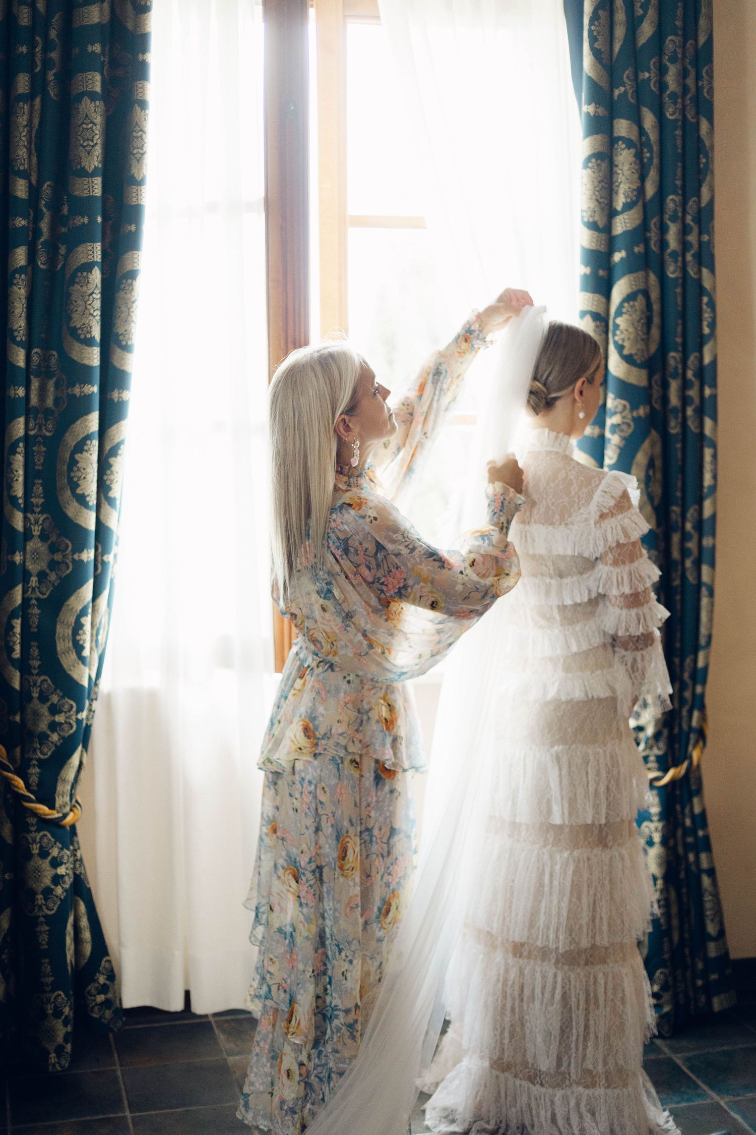 Sunlit window scene with flowing white dress and patterned curtains.