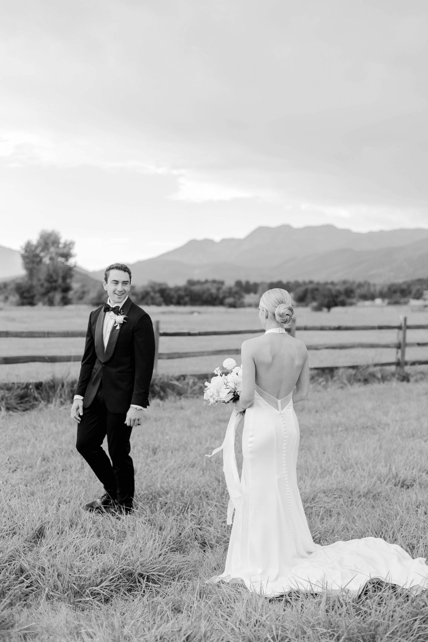 Romantic black and white wedding portrait in mountain landscape setting.