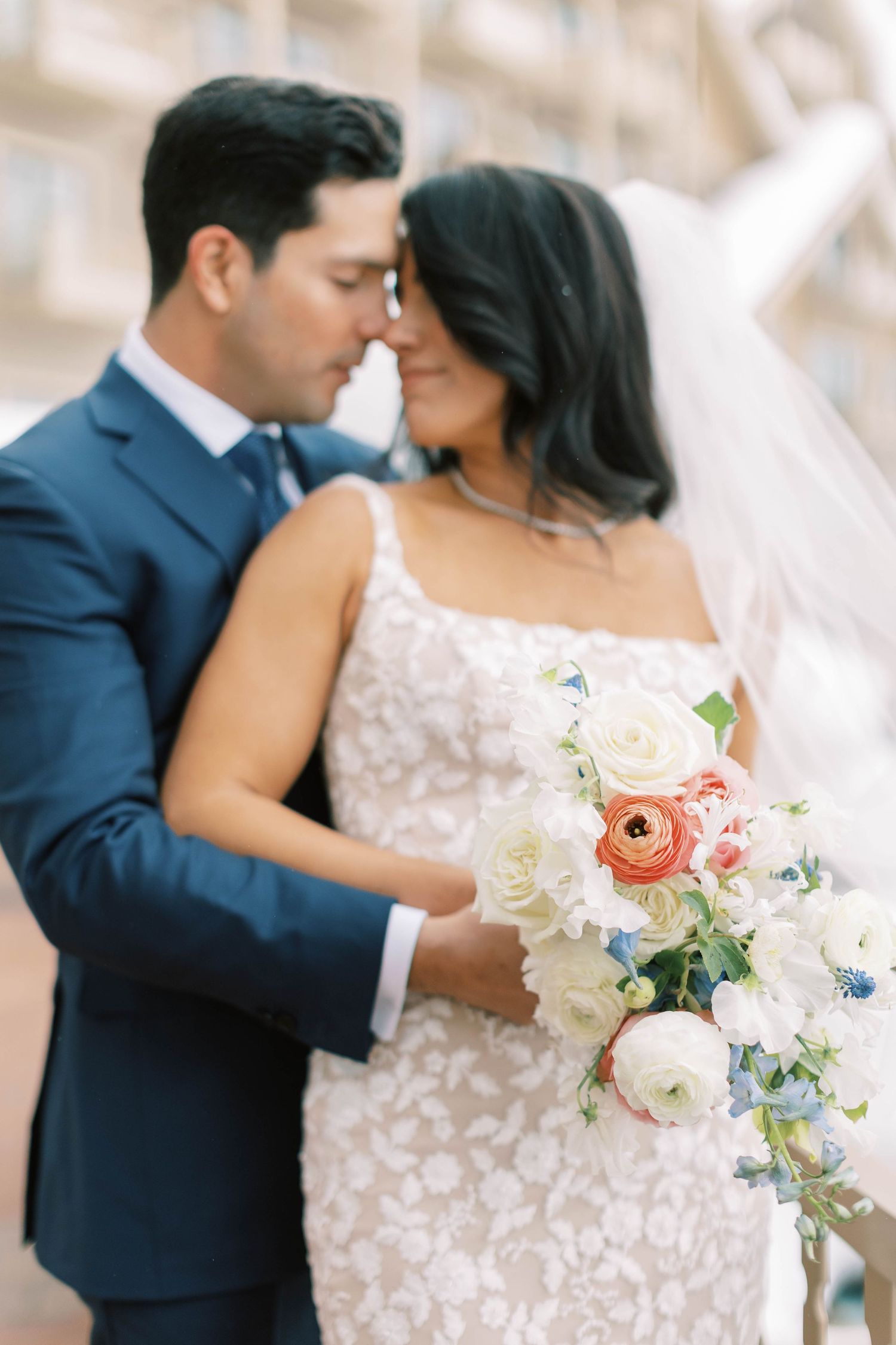 An elegant bridal bouquet of pink and white flowers complements a tender wedding moment.