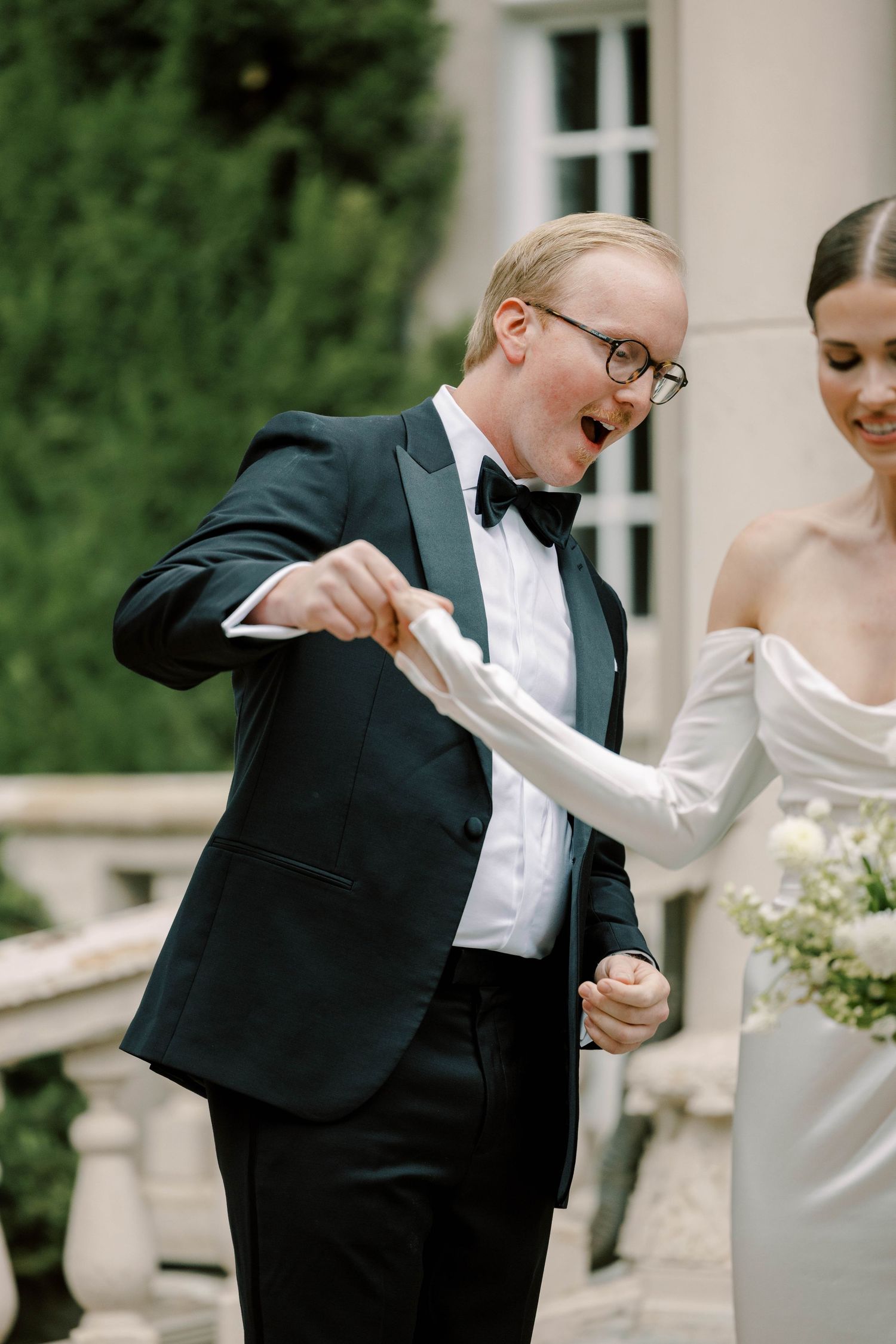Candid moment of laughter shared during outdoor wedding portraits.