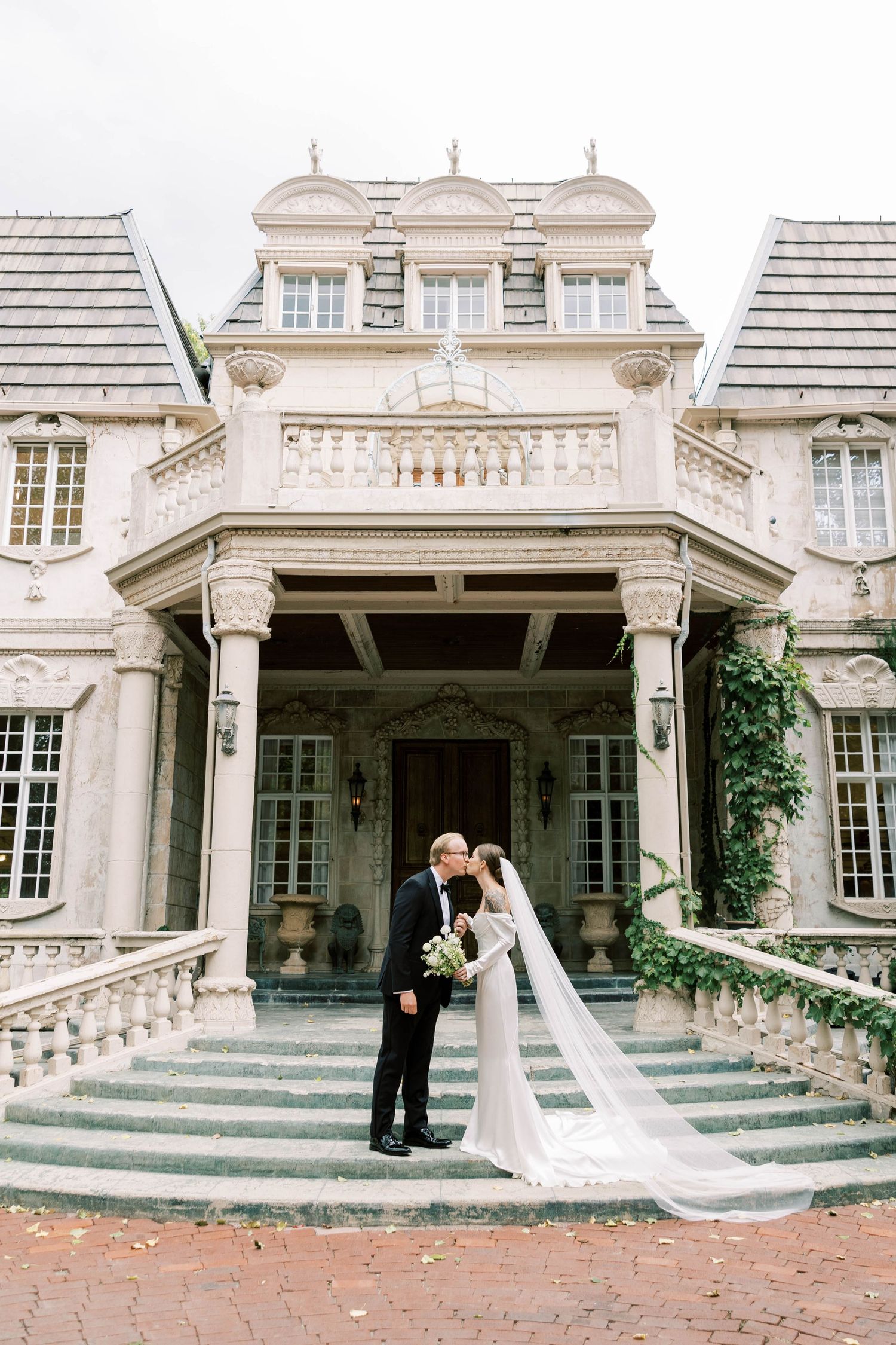 Classic white mansion with ornate architecture and grand entrance staircase.