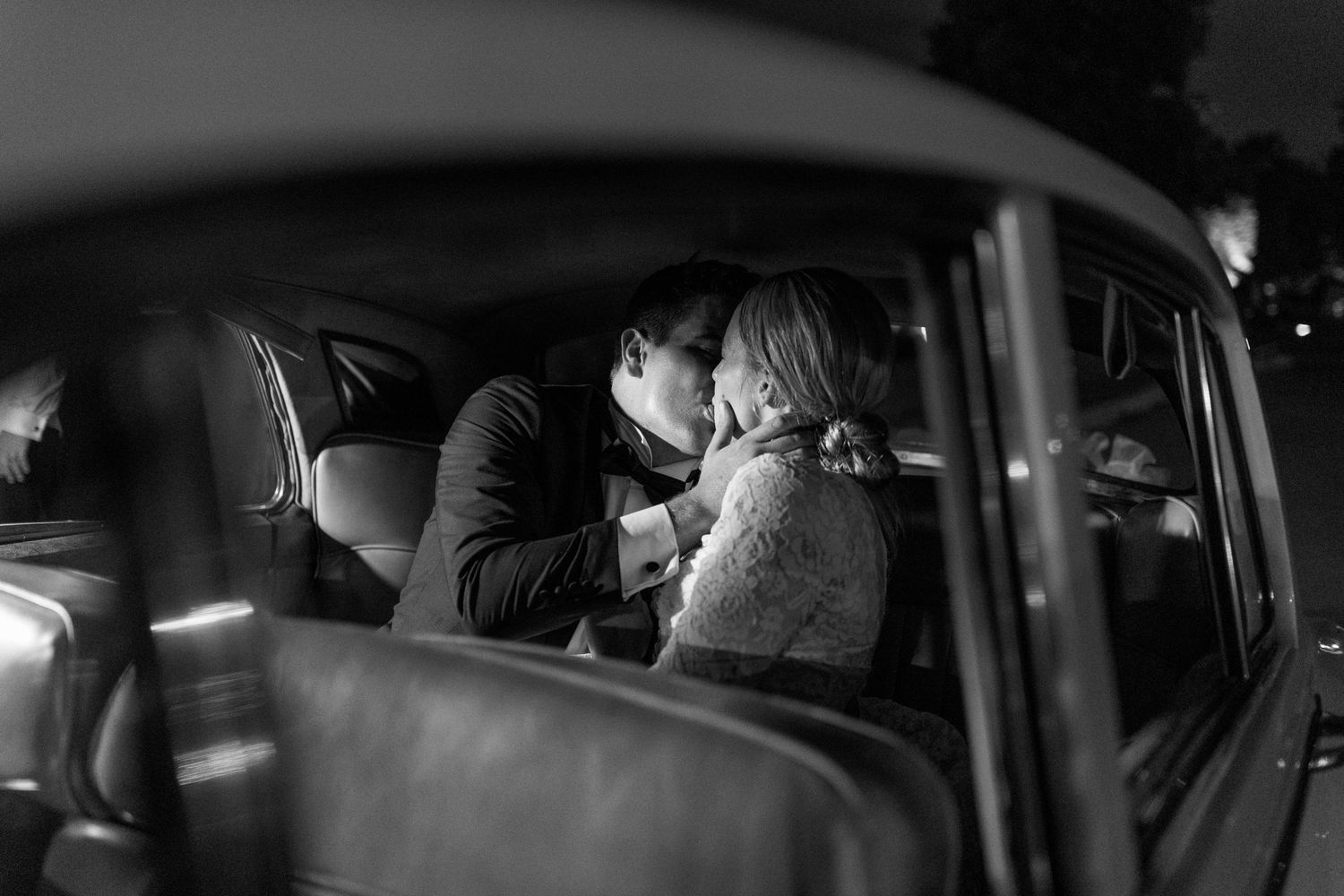 Romantic moment captured through vintage car window at night.
