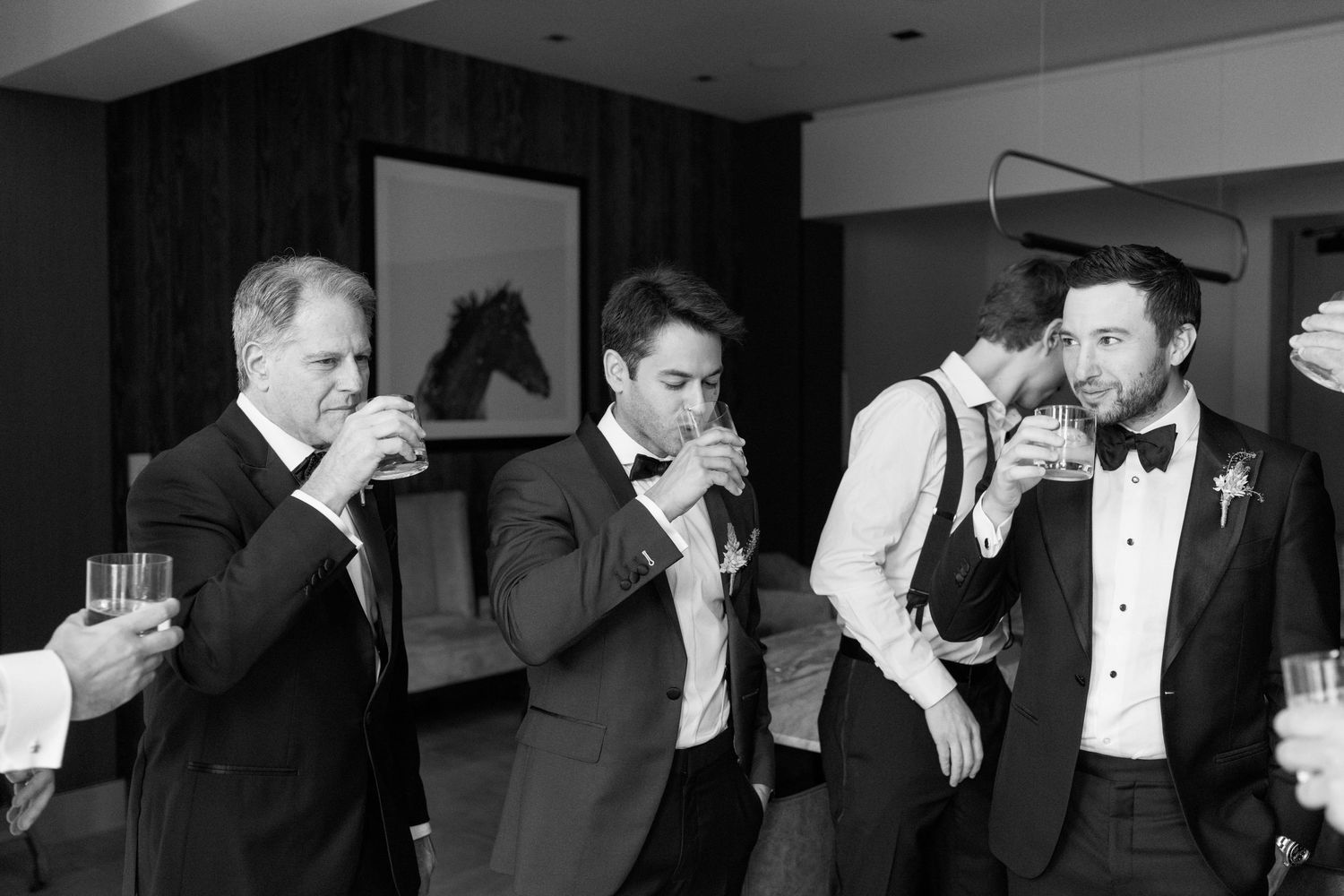 Black and white photo of groomsmen drinking and celebrating.