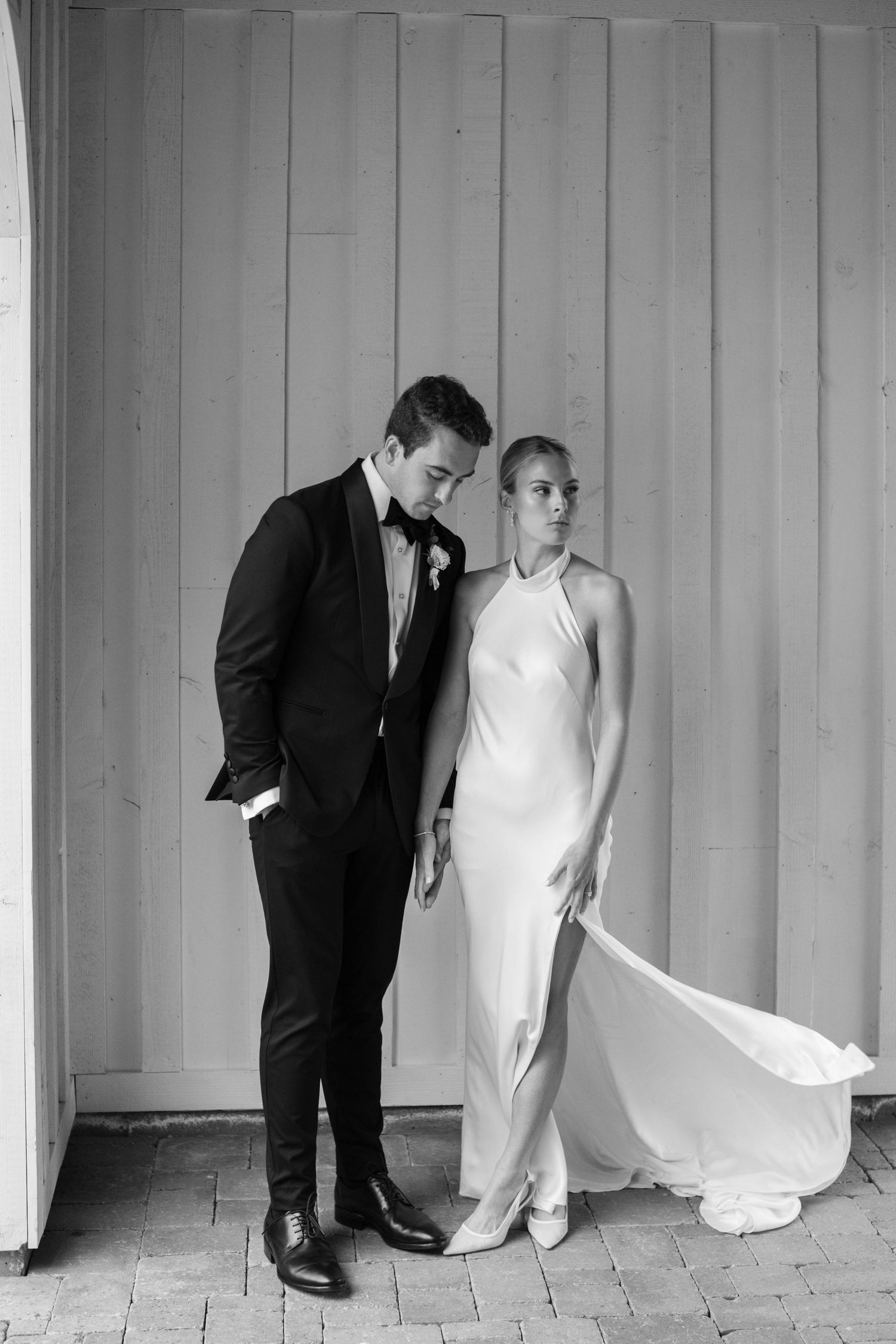 Modern minimalist wedding portrait against white paneled wall.
