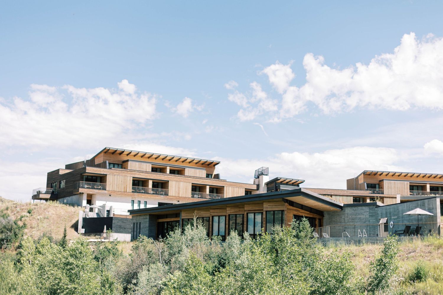 Contemporary mountain resort buildings nestled into a hillside with dramatic architectural design.
