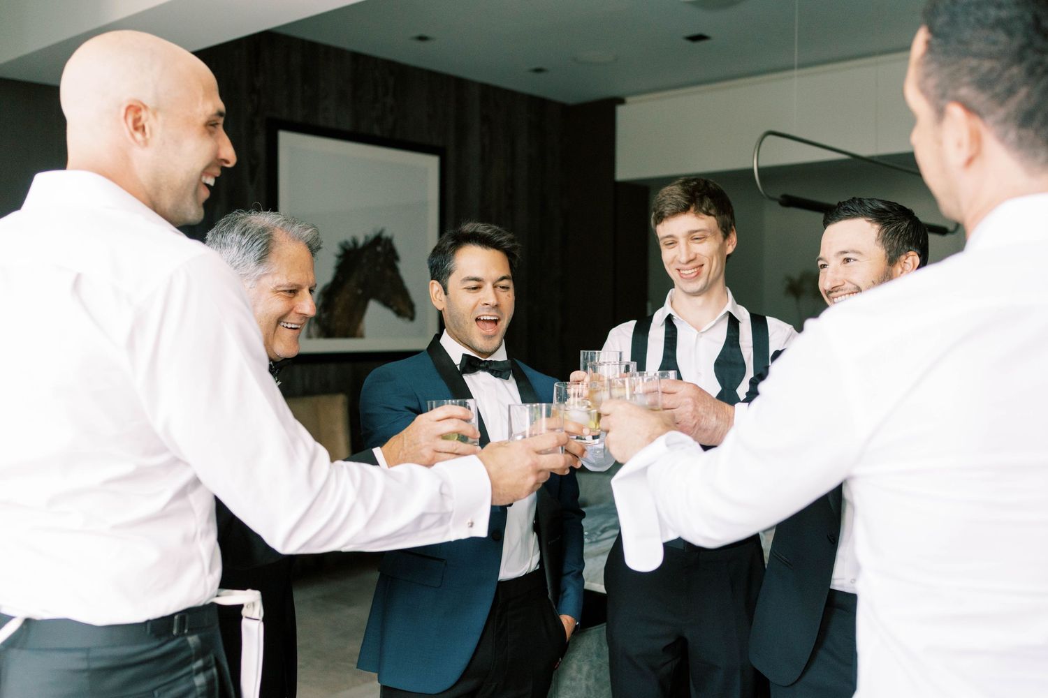 Wedding party raising glasses in celebratory toast.