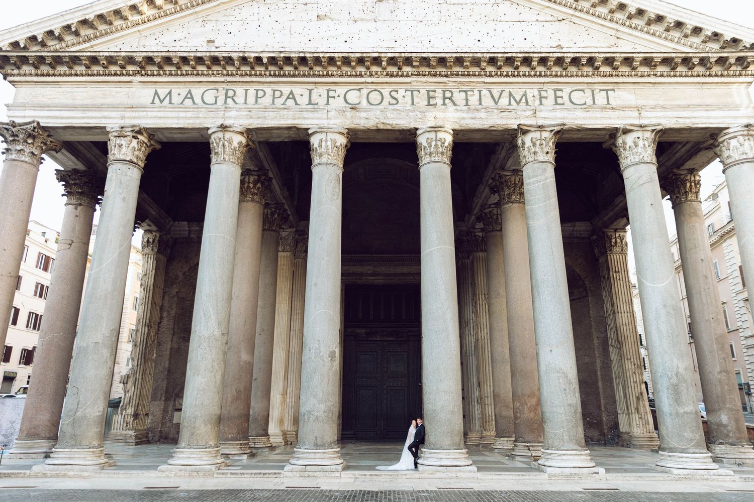 Majestic columns of the Pantheon in Rome with a newlywed wedding couple sharing first look.