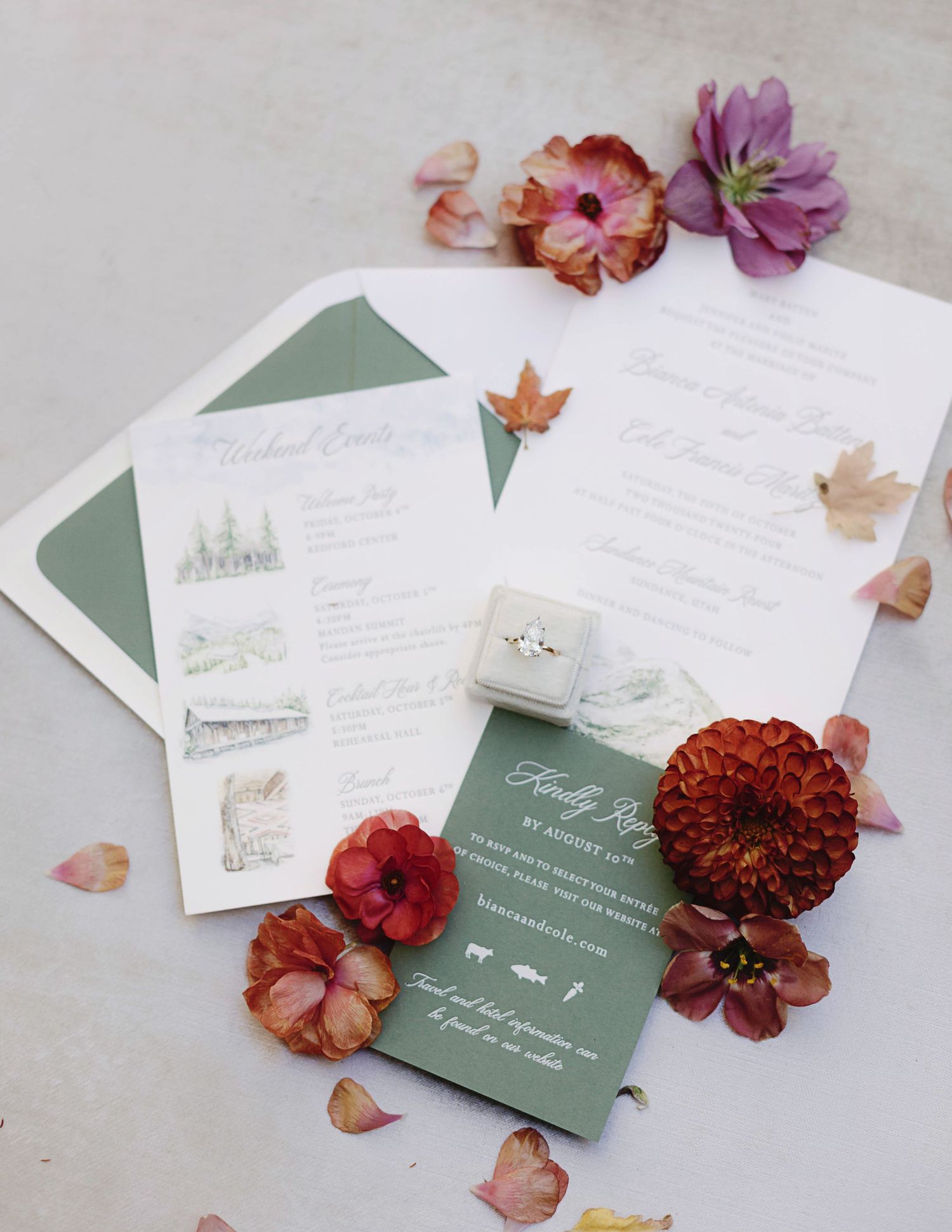 Wedding invitation suite with sage green envelopes decorated with autumn flowers and fallen leaves.