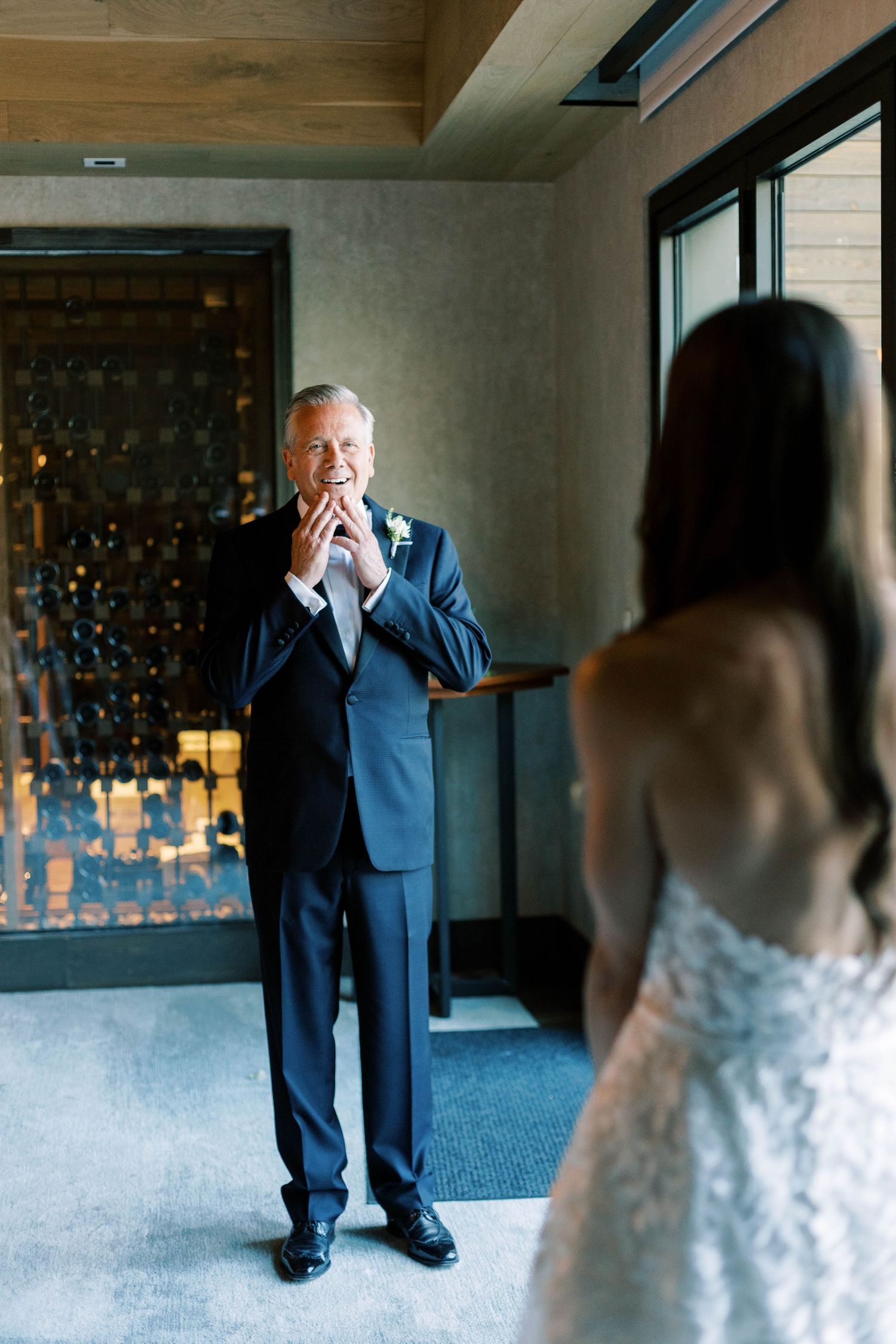 A touching reaction during a wedding first look with a person in a blue suit.