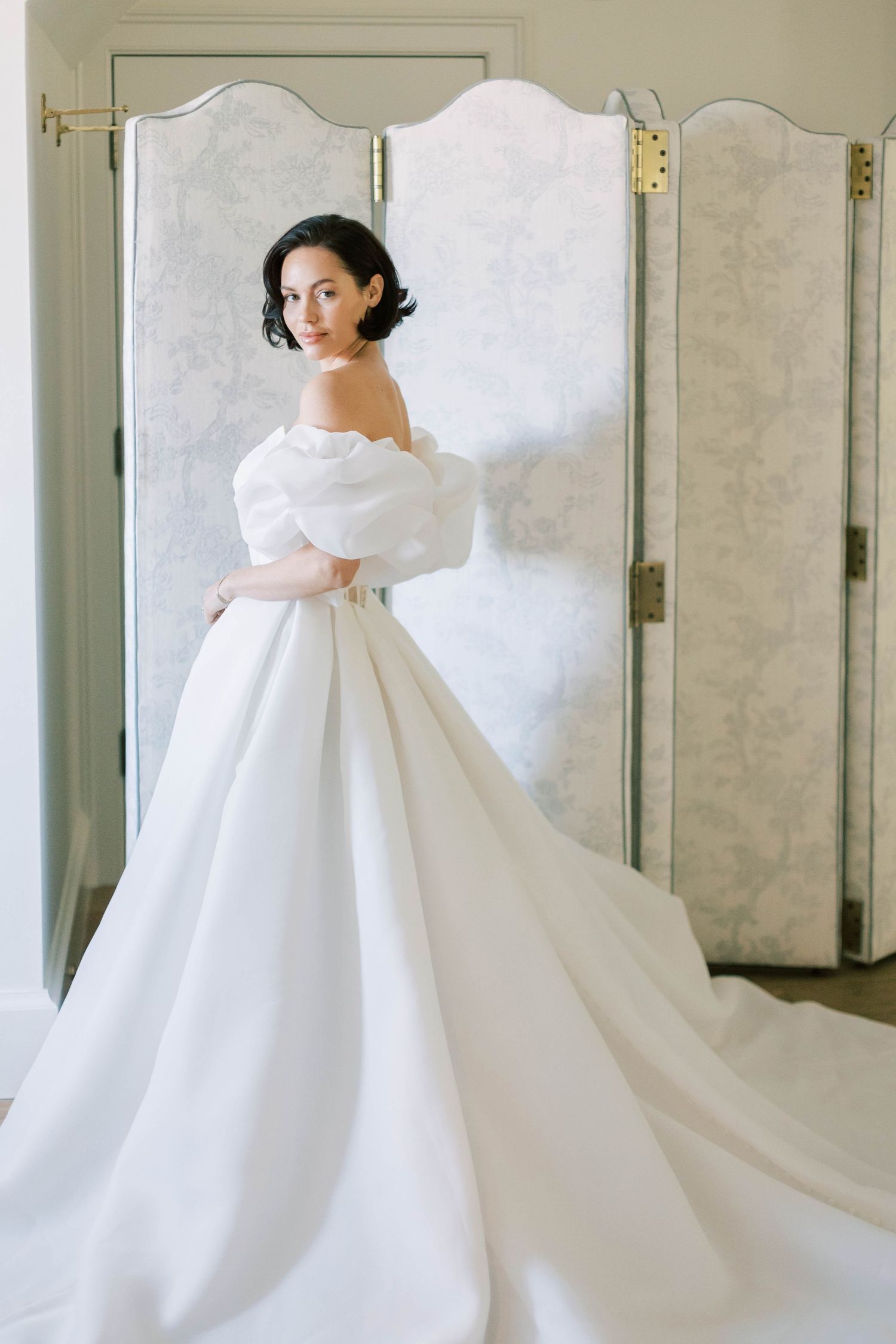 A classic ballgown wedding dress with dramatic puff sleeves and flowing train.