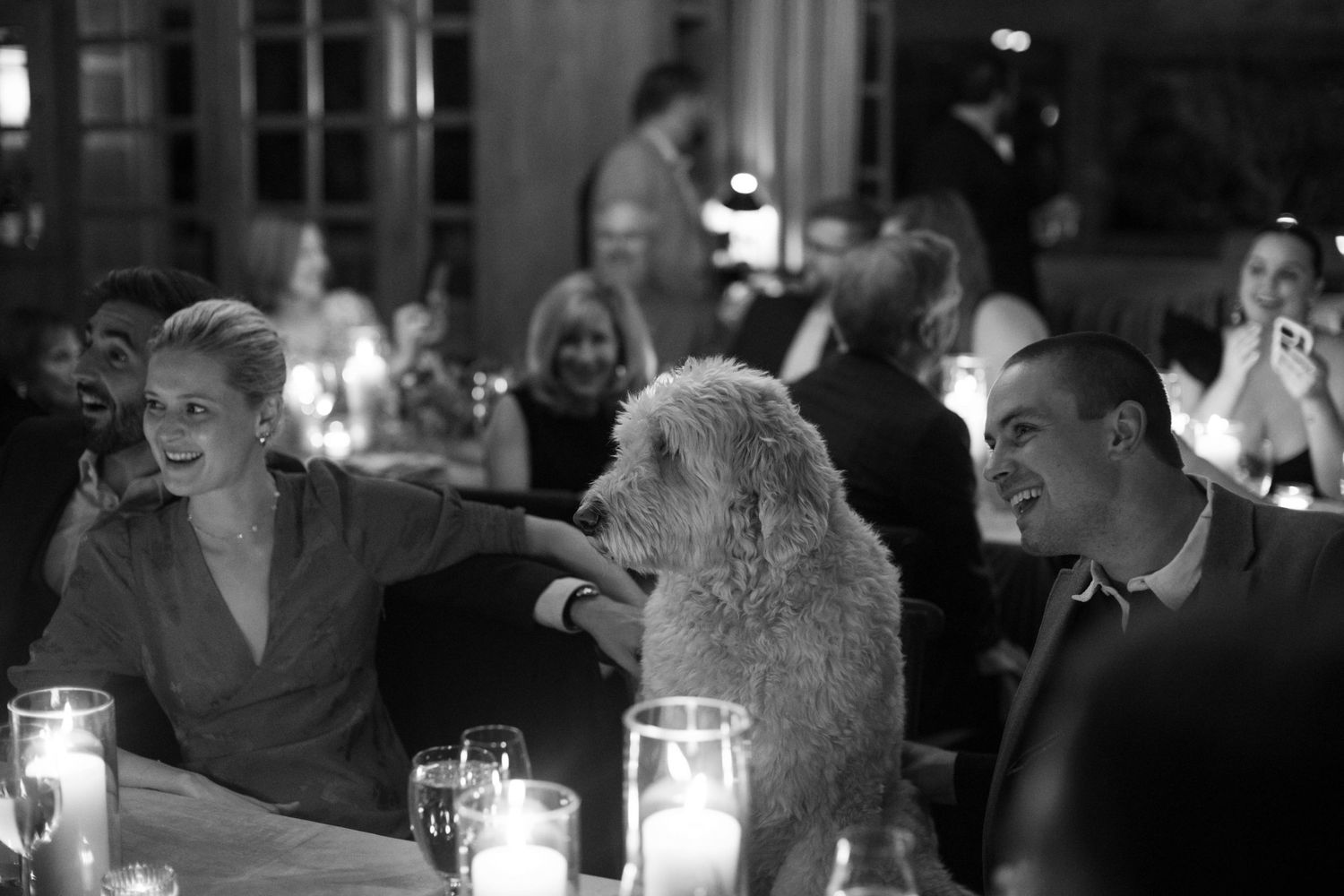 Guests seated at a candlelit dinner table during an elegant evening event at promontory park city.