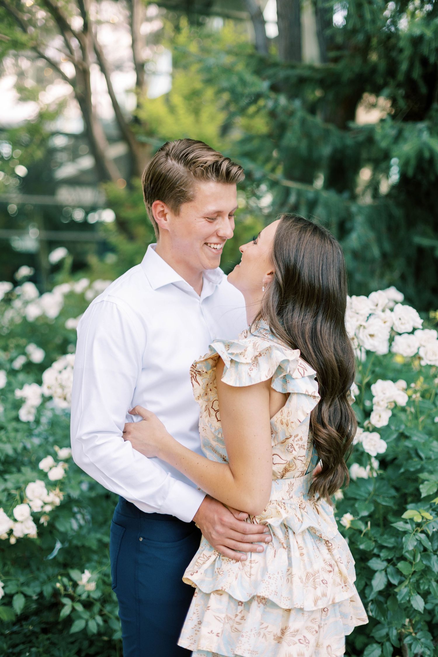 A joyful moment captured in a garden filled with blooming roses.